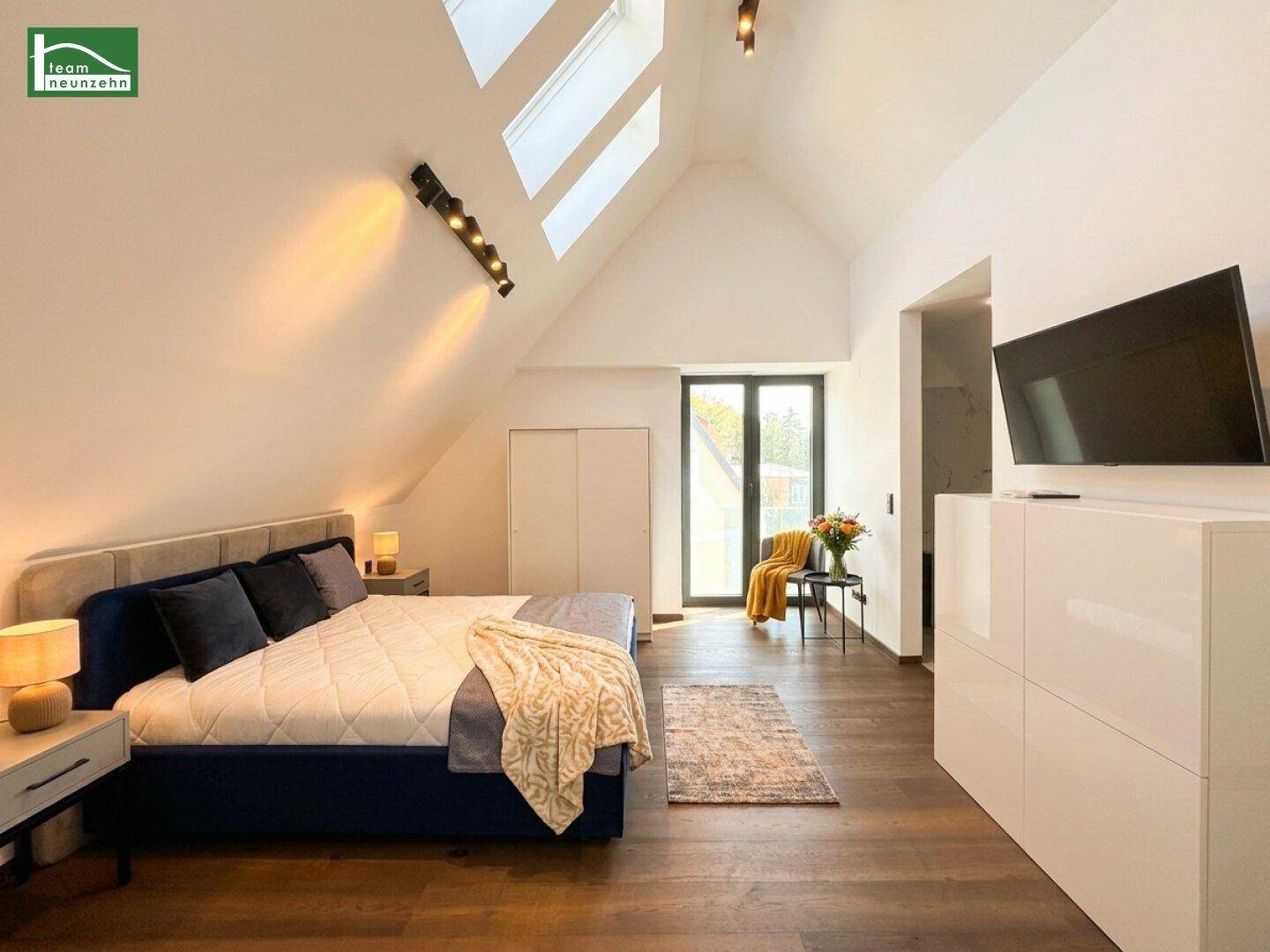 Geräumiges Schlafzimmer mit Holzboden, hohen Decken und Zugang zum Balkon.