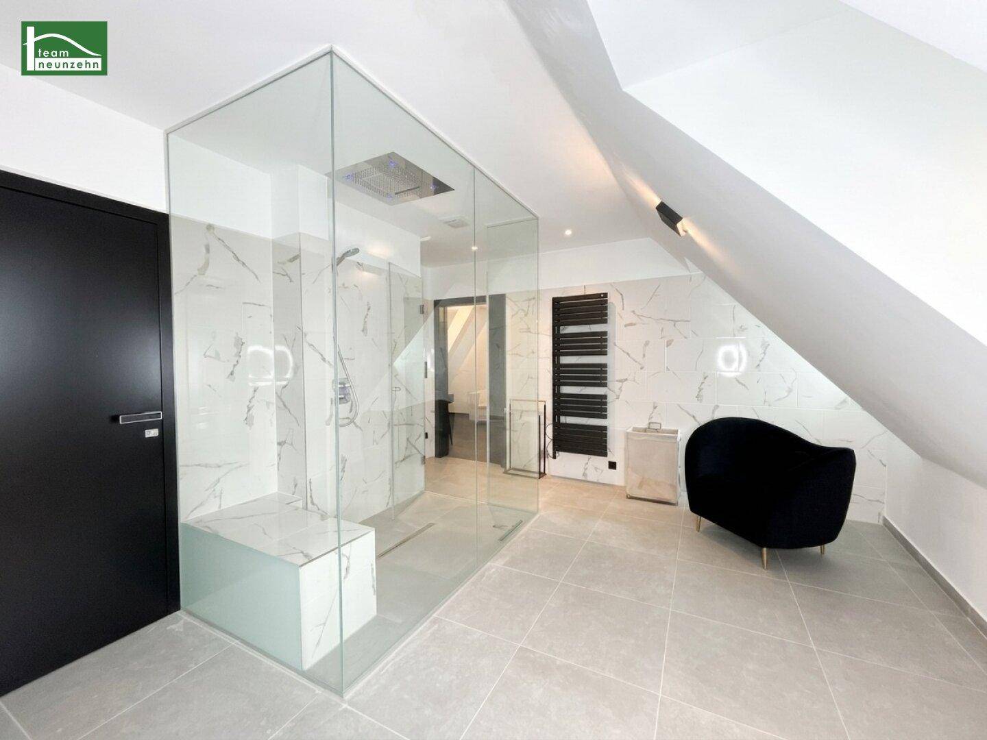Geräumiges Badezimmer mit moderner begehbarer Dusche und eleganten Marmorfliesen.