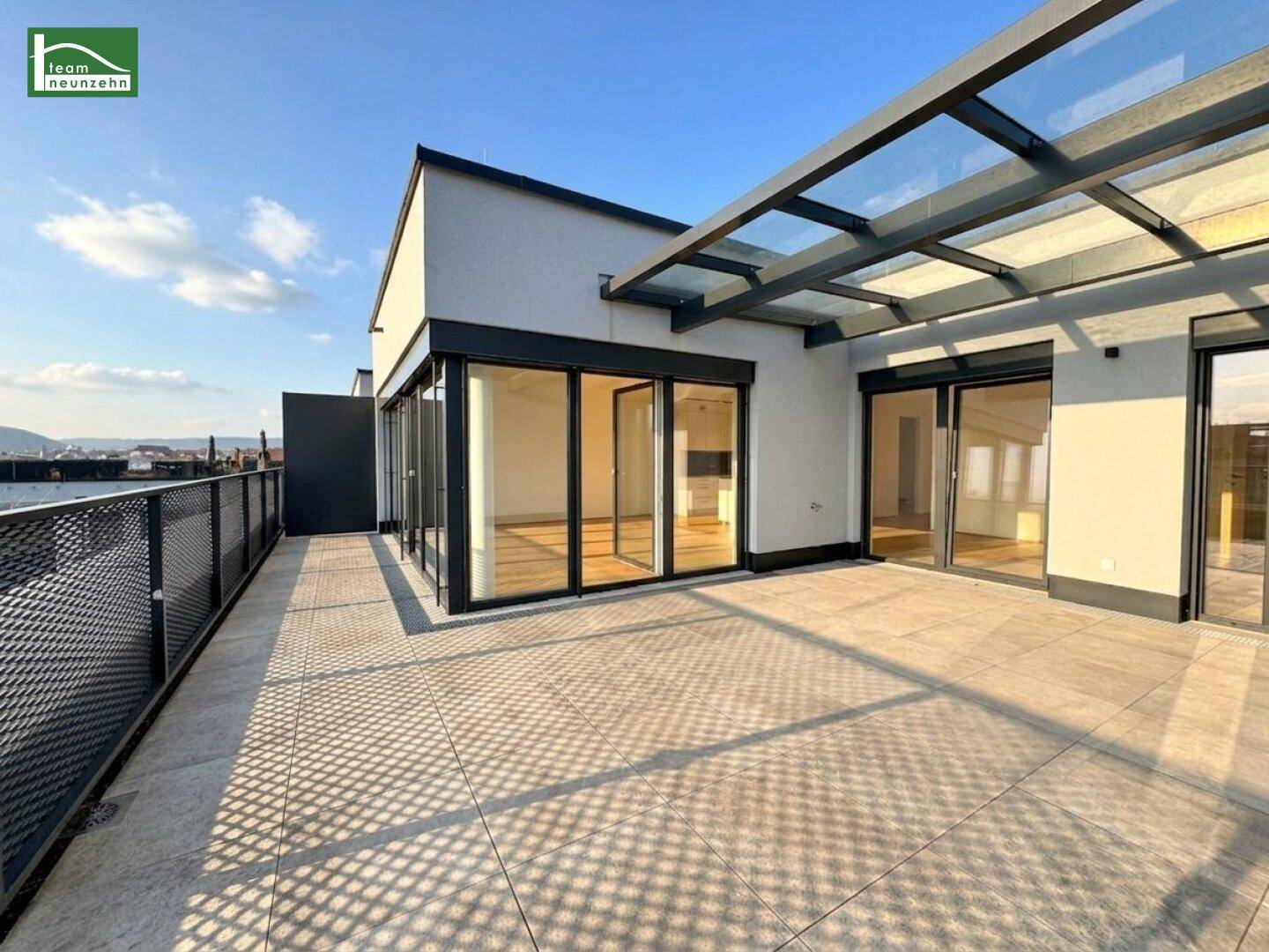 Große Dachterrasse mit Fliesenboden und Glasüberdachung, ideal für entspannte Stunden im Freien.