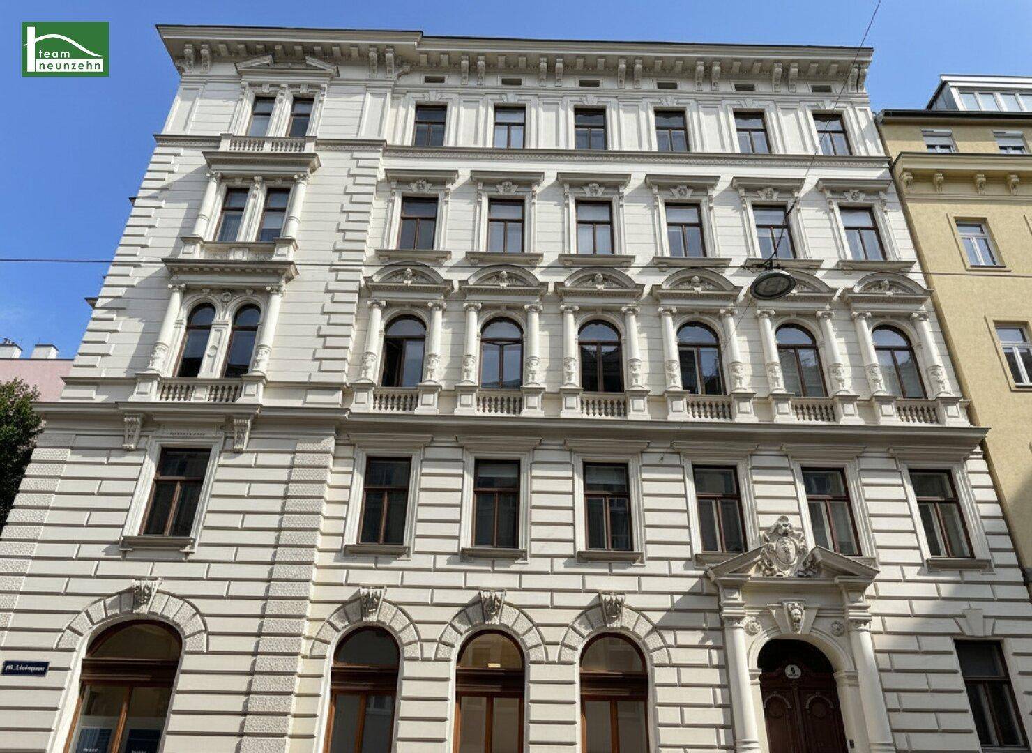 Prächtige Fassade eines historischen Gebäudes mit vielen Fenstern und Balkonen.