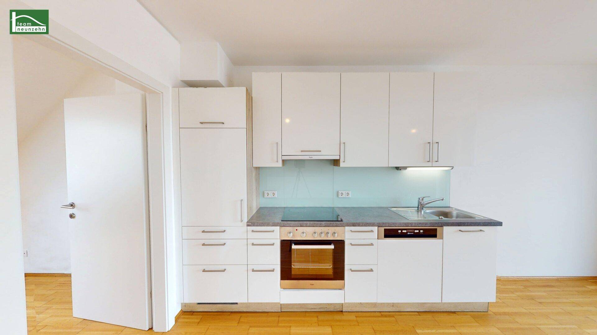 Moderne Einbauküche mit weißen Hochglanzfronten, Induktionskochfeld, Backofen und Geschirrspüler.