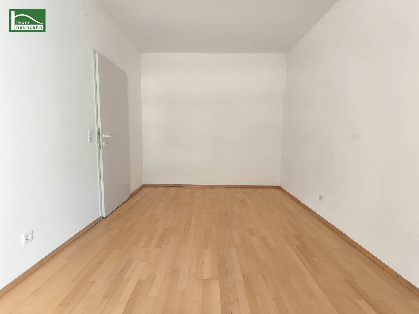 Leeres Zimmer mit hellem Parkettboden und weiß gestrichenen Wänden, ideal für individuelle Gestaltung.