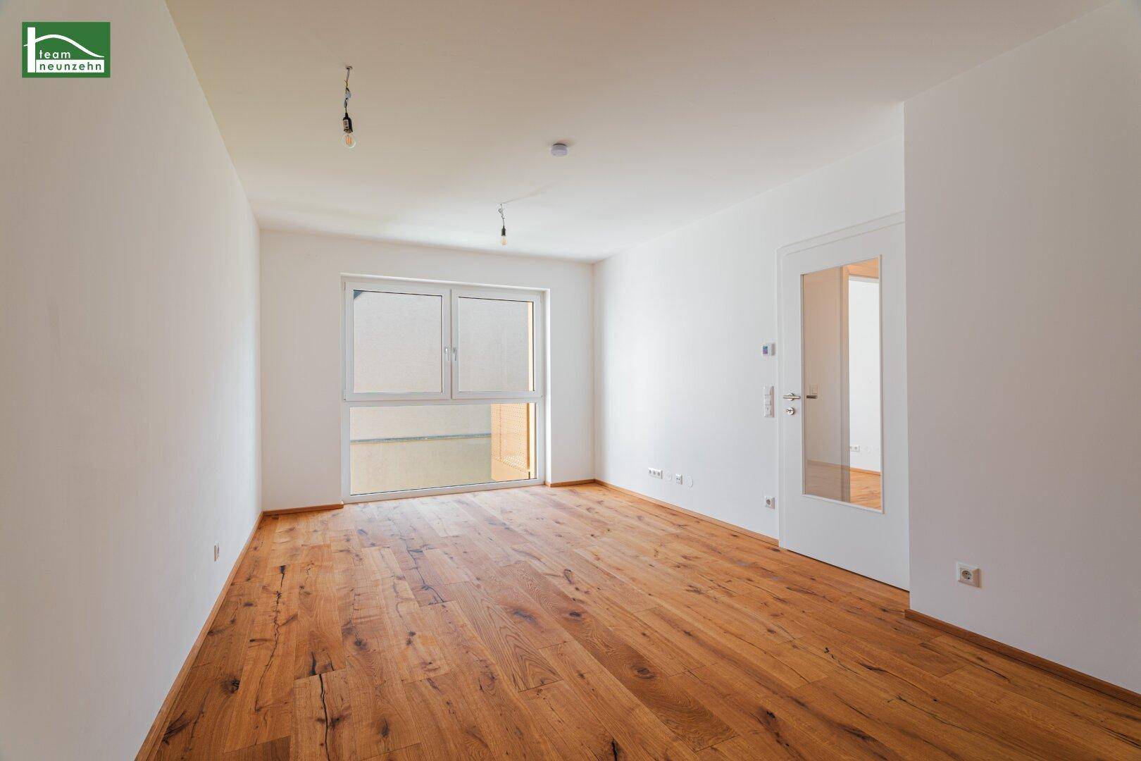 Geräumiges, helles Zimmer mit Holzboden und Fenster, ideal als Wohn- oder Schlafbereich.