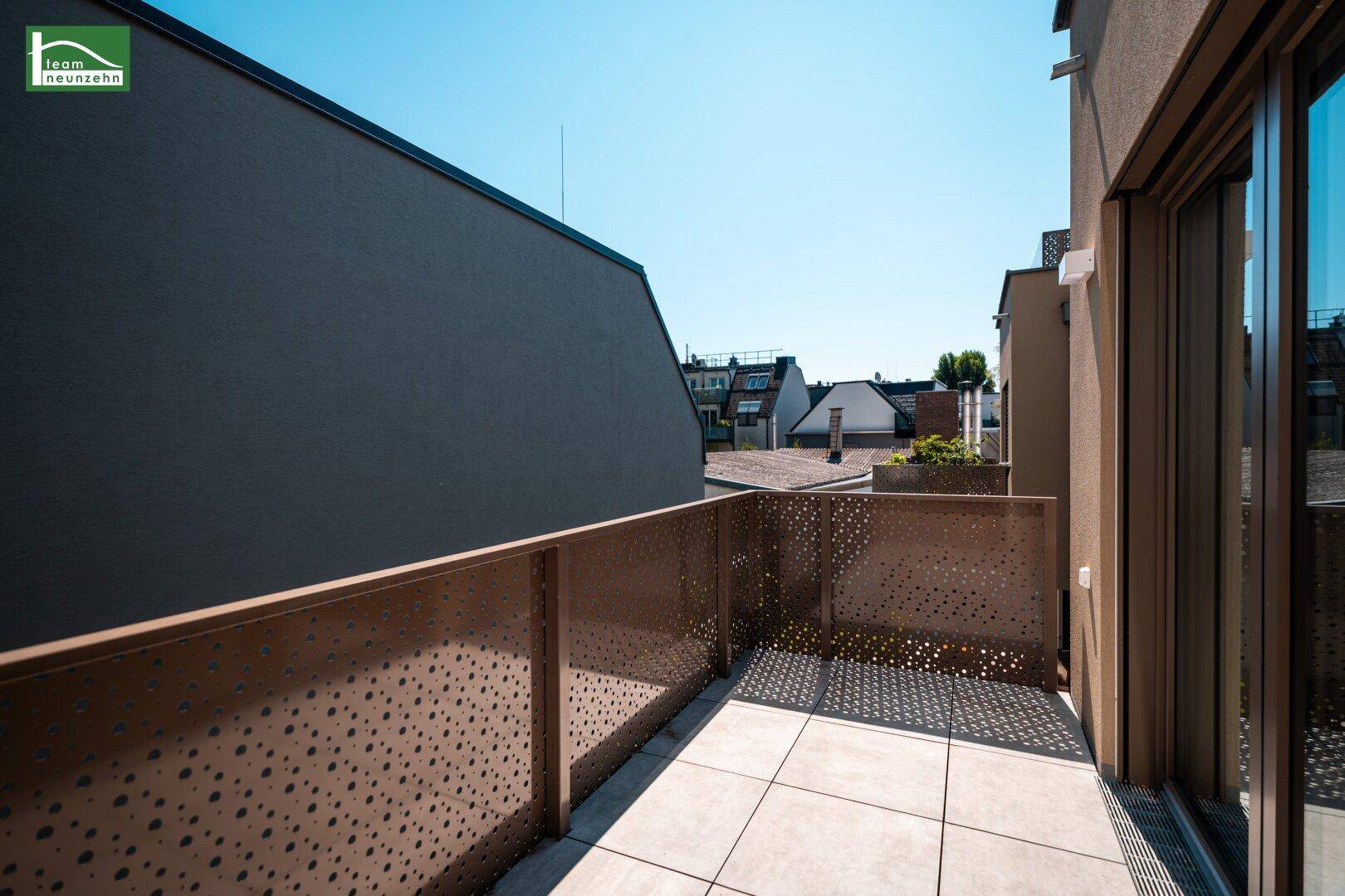 Sonniger Balkon mit modernen perforierten Geländern und Blick auf die Umgebung.