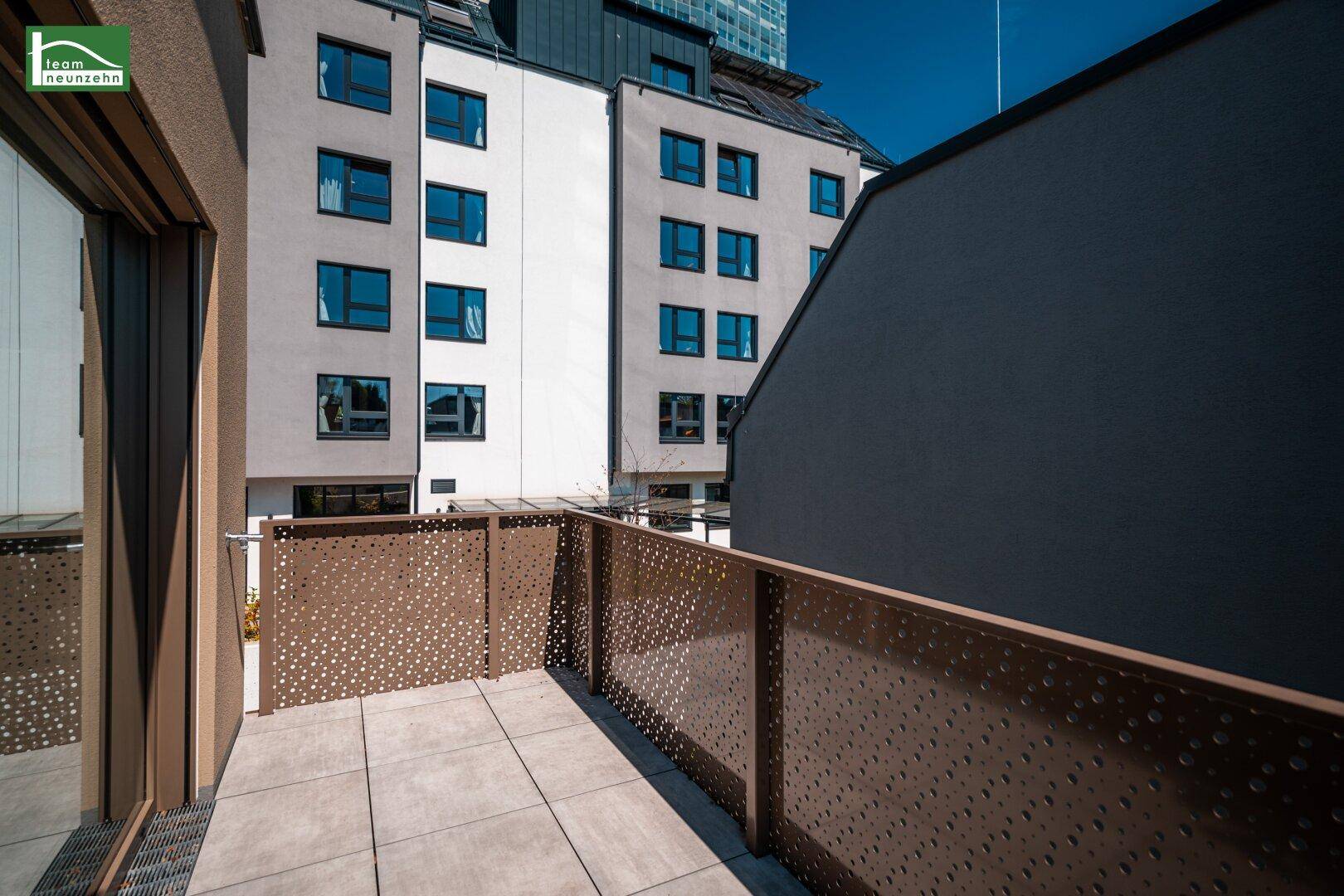 Heller Balkon mit Blick auf die Stadt und angrenzende Gebäude, ideal für Entspannung.