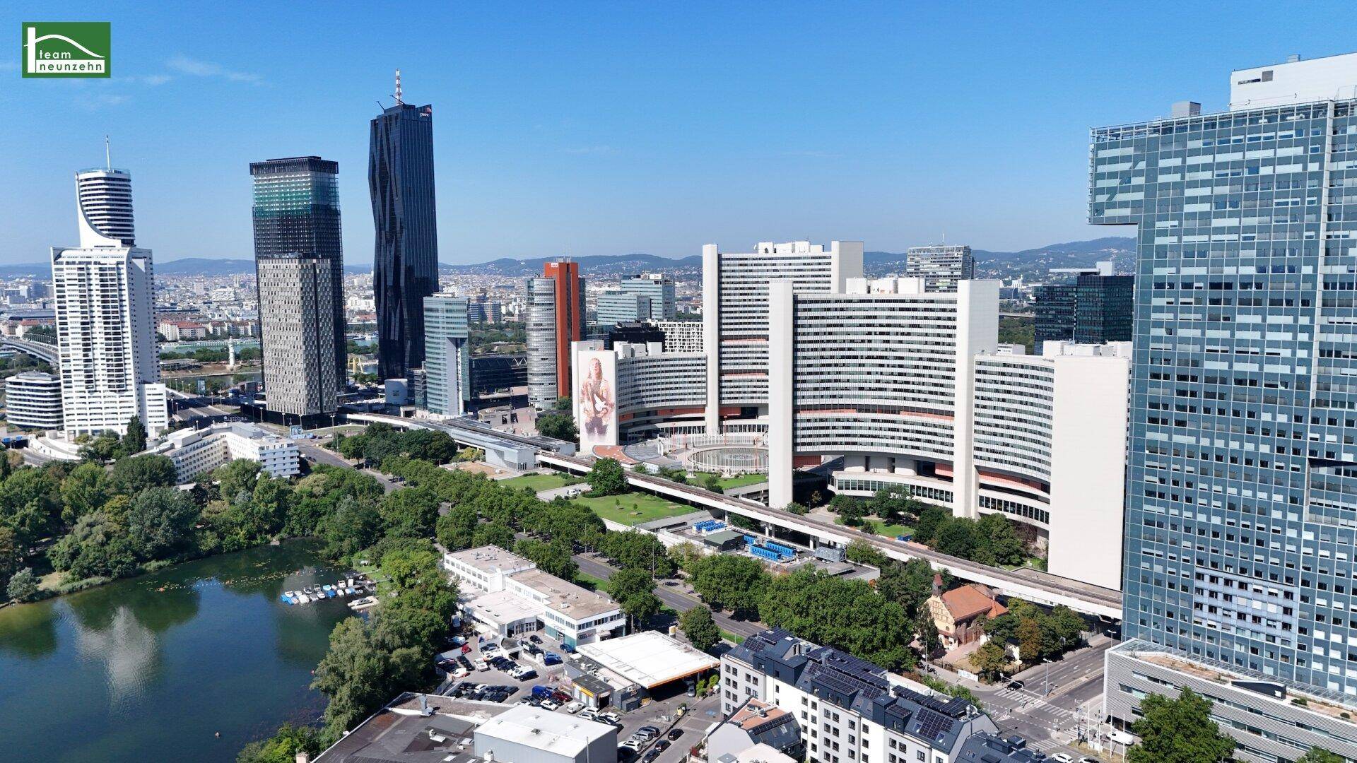 Panoramablick auf die moderne Stadtlandschaft mit Hochhäusern und Grünflächen.