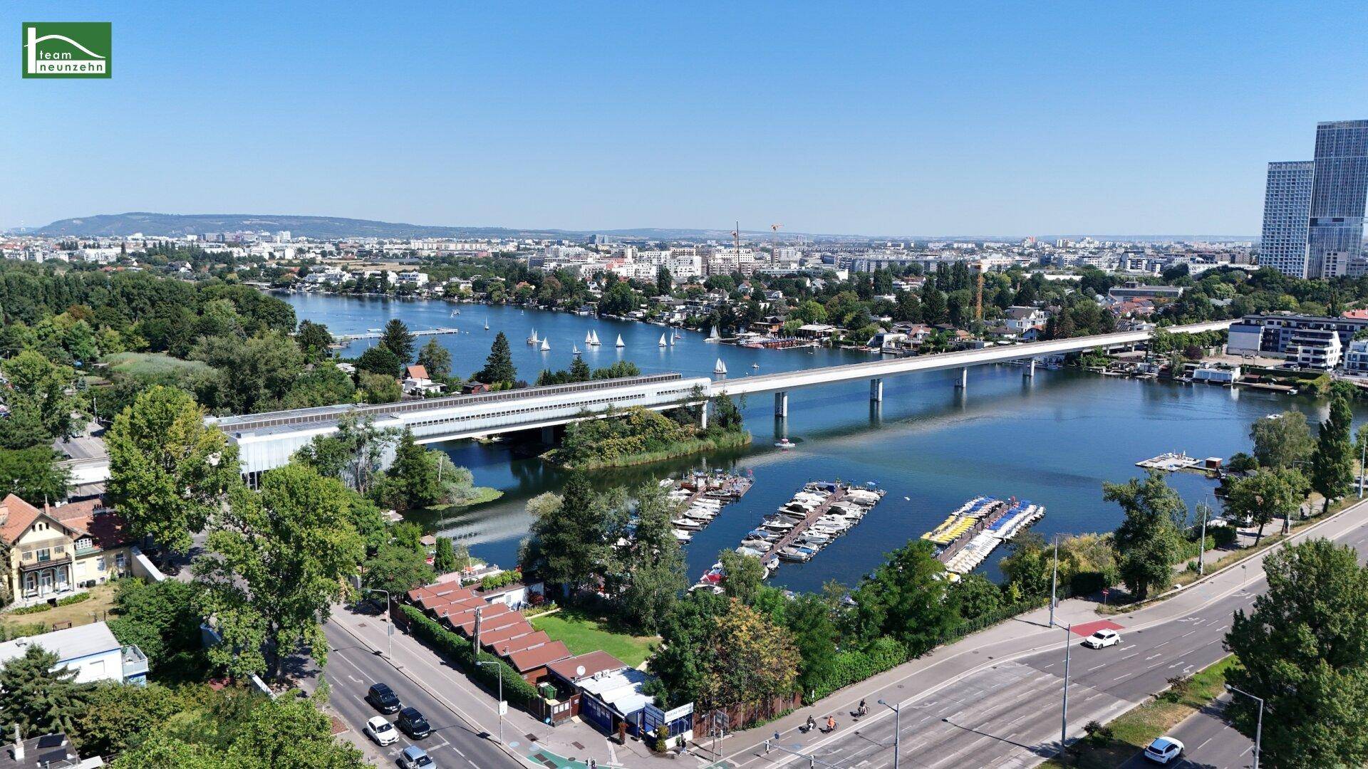 Weitläufige Luftaufnahme der Stadt mit Fluss, Brücke und urbaner Bebauung.