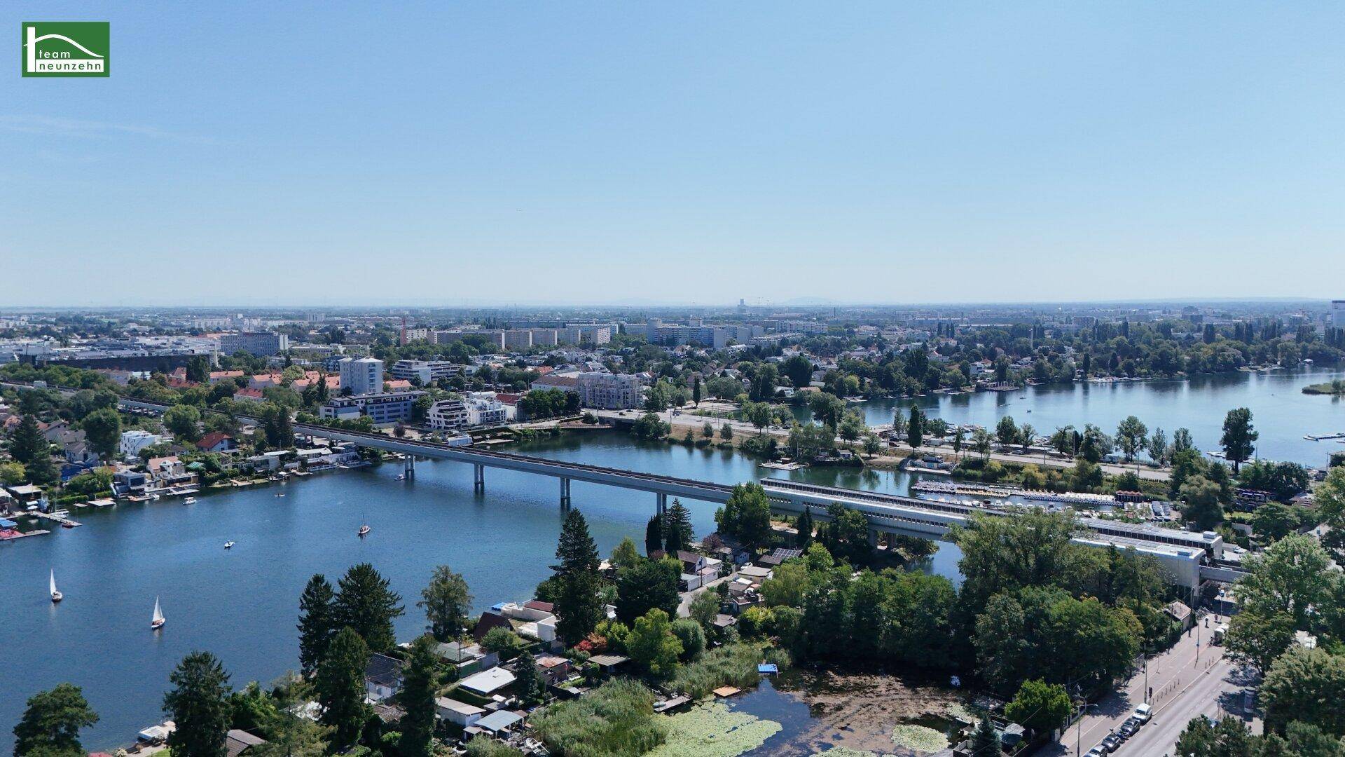 Panoramablick aus der Luft auf die Stadt mit Seen, Brücken und Wohngebieten.