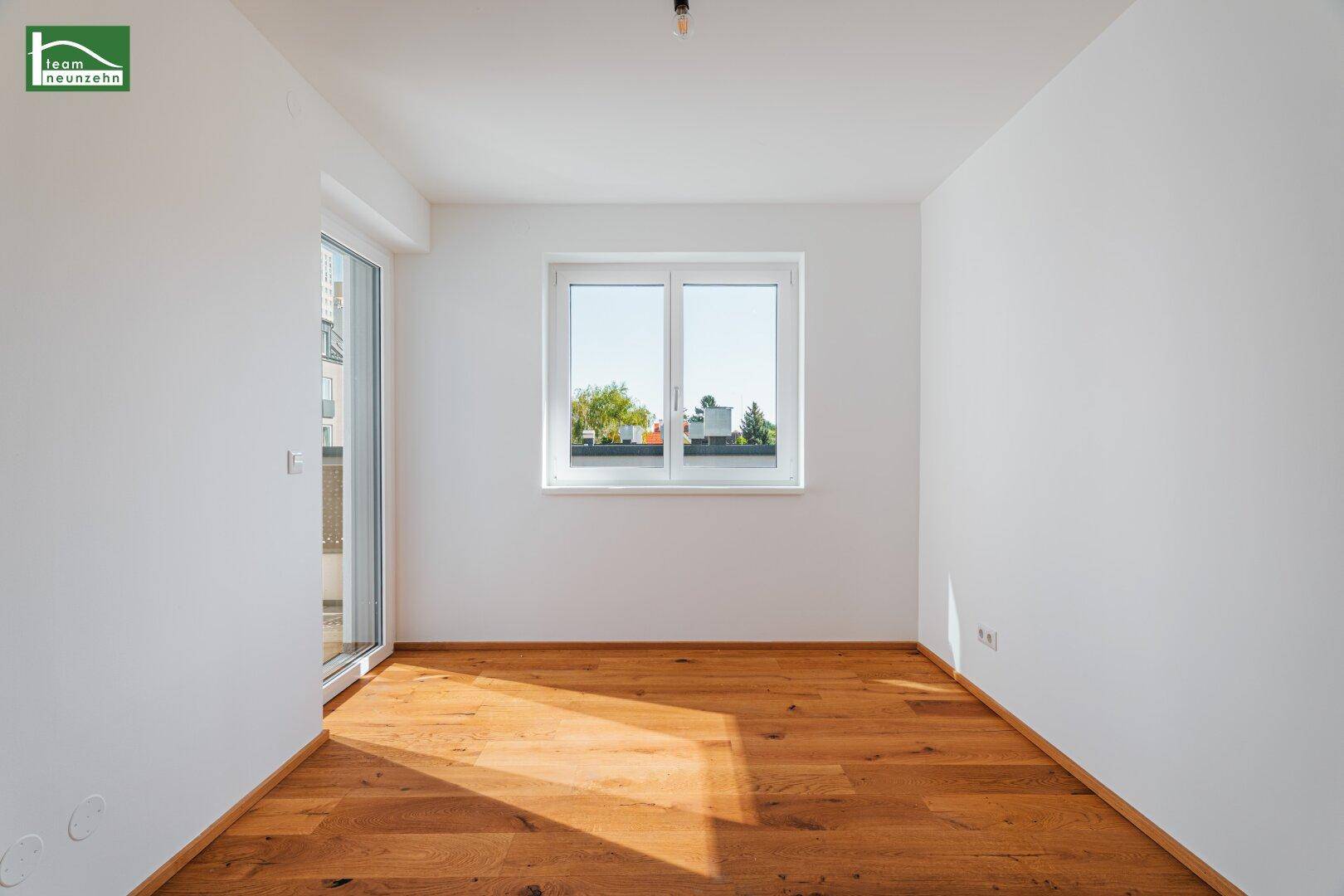Leeres, helles Zimmer mit Holzboden und Fenster, ideal als Schlaf- oder Arbeitszimmer.