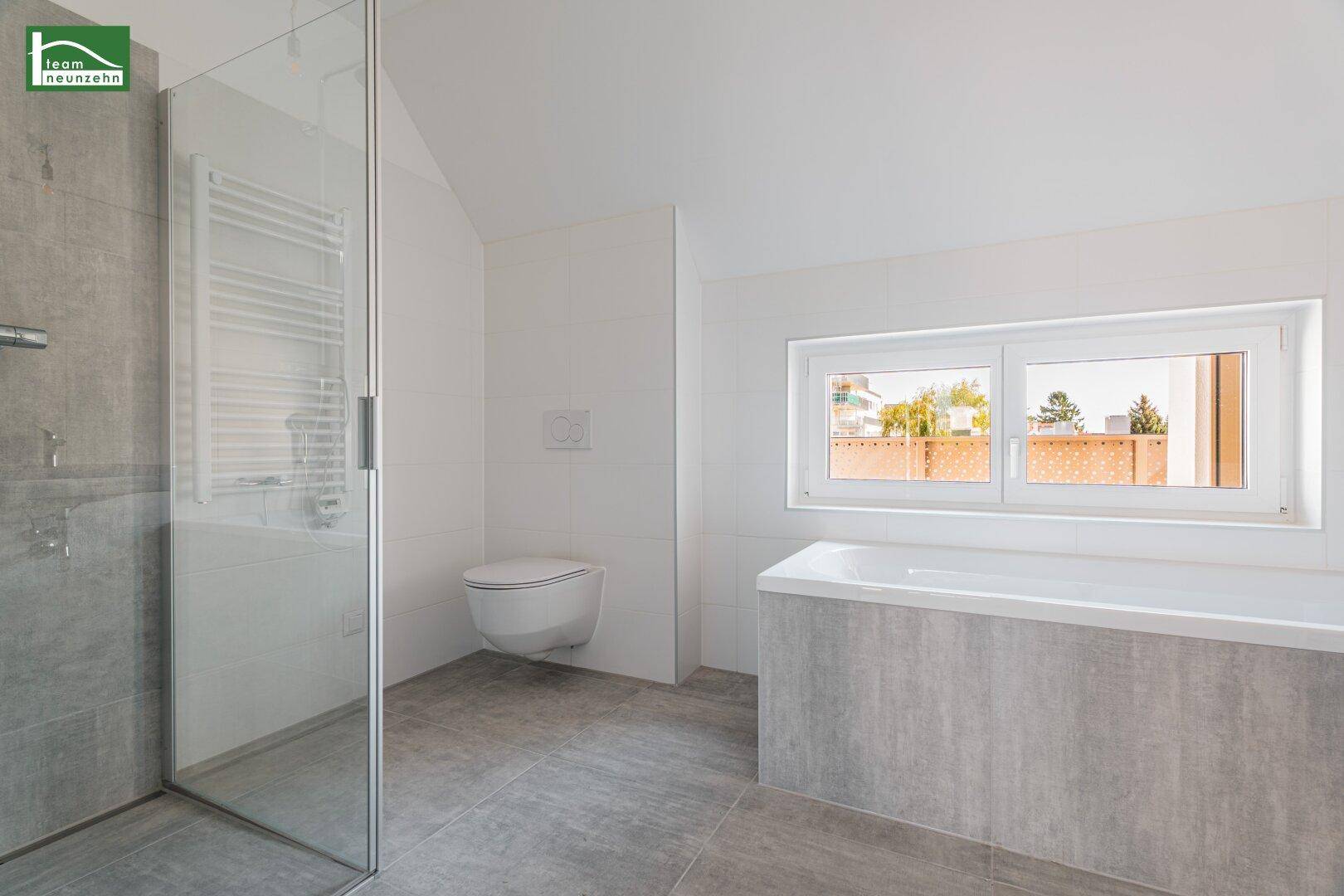 Modernes Badezimmer mit Badewanne, Duschkabine und Fenster für natürliche Belüftung.