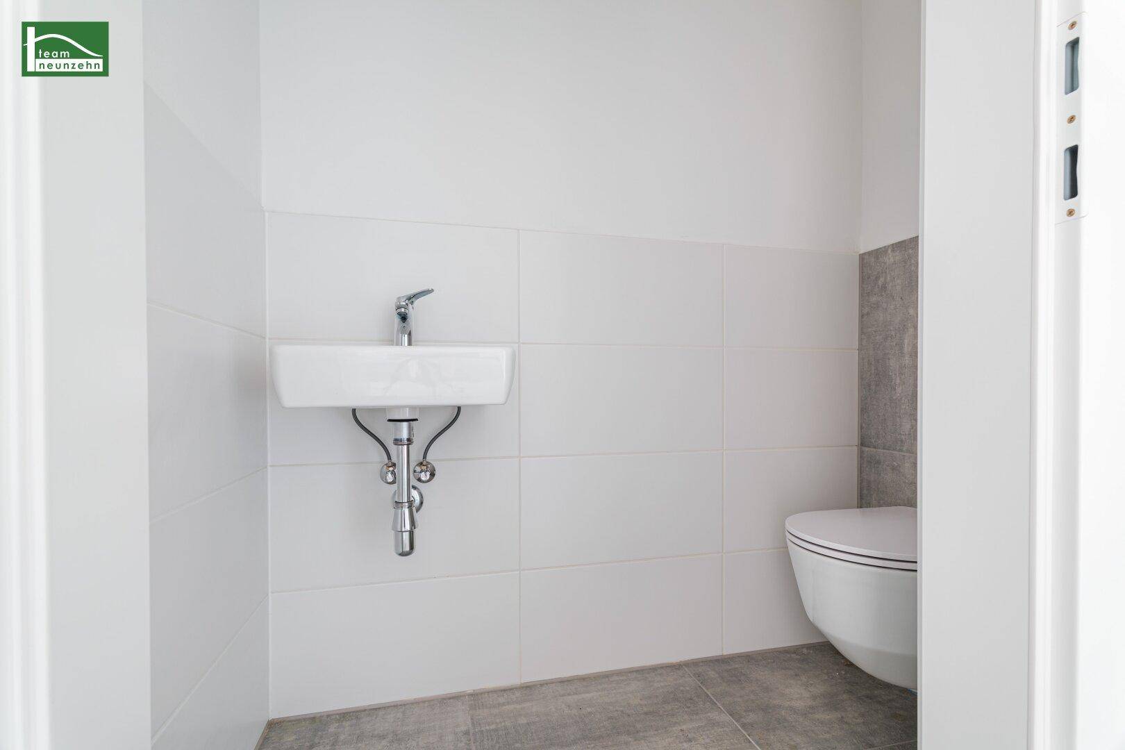 Kleines Gäste-WC mit modernem Waschbecken und wandhängender Toilette.