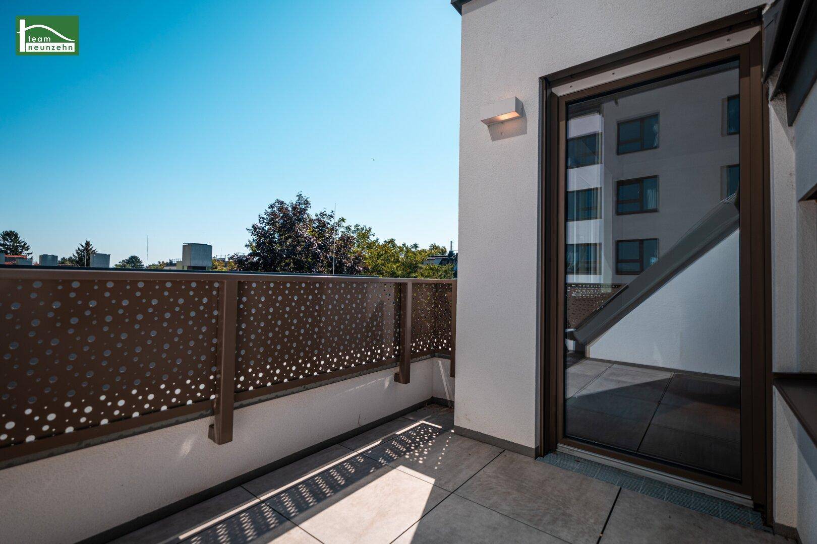 Heller Terrassenbereich mit moderner Brüstung und Zugang zum Innenraum.