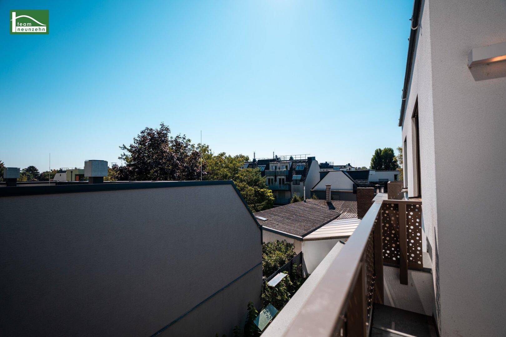 Terrasse mit weitem Blick über die Dächer der Stadt und grüne Umgebung.