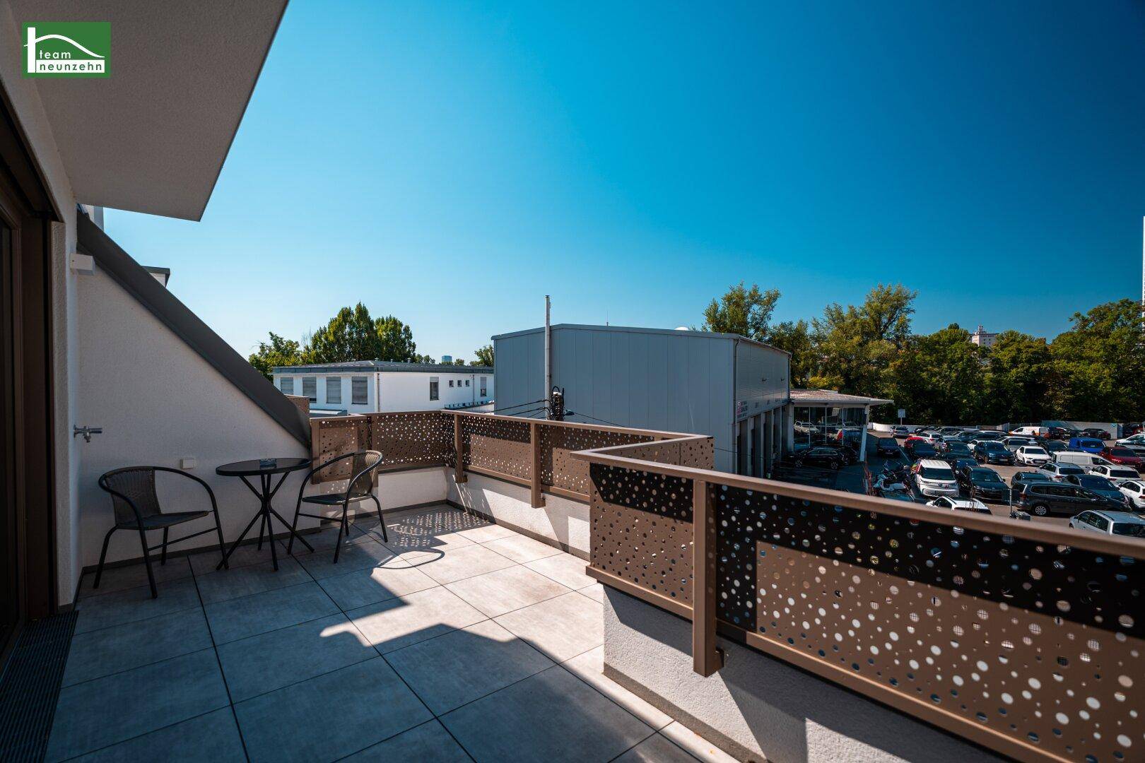 Weitläufige Terrasse mit Sitzgelegenheiten und Blick auf die umliegende Bebauung.