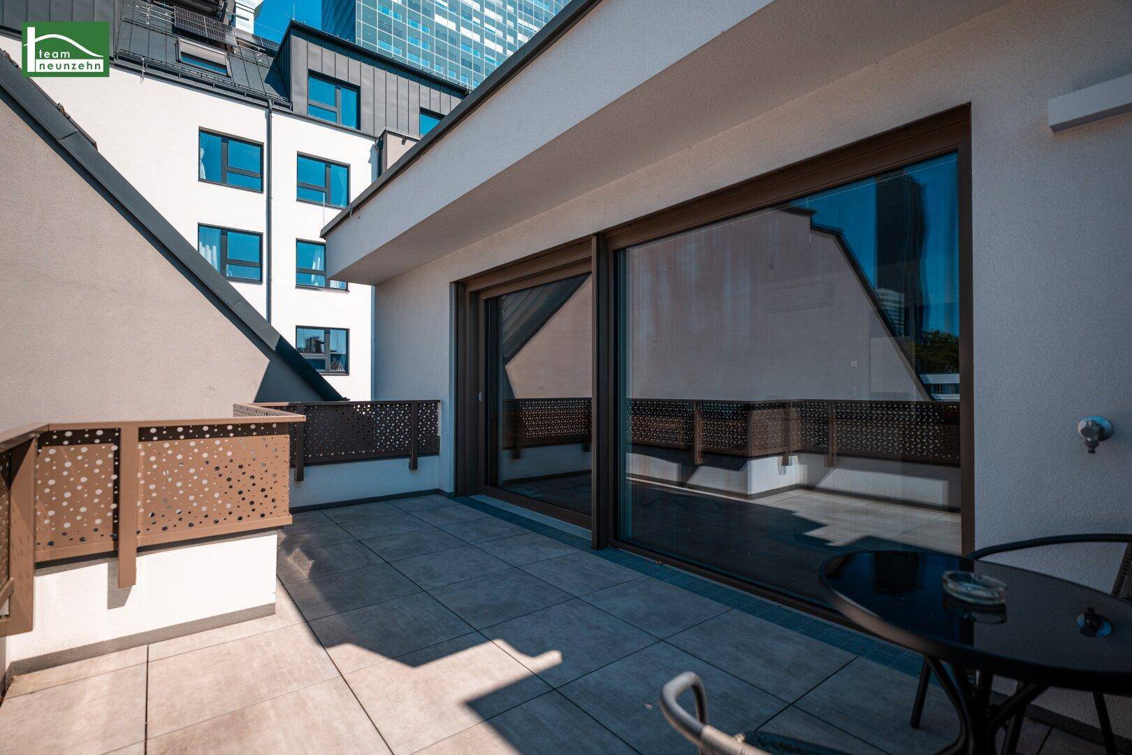 Geräumige Terrasse mit Fliesenboden und moderner Brüstung, bietet viel Platz im Freien.