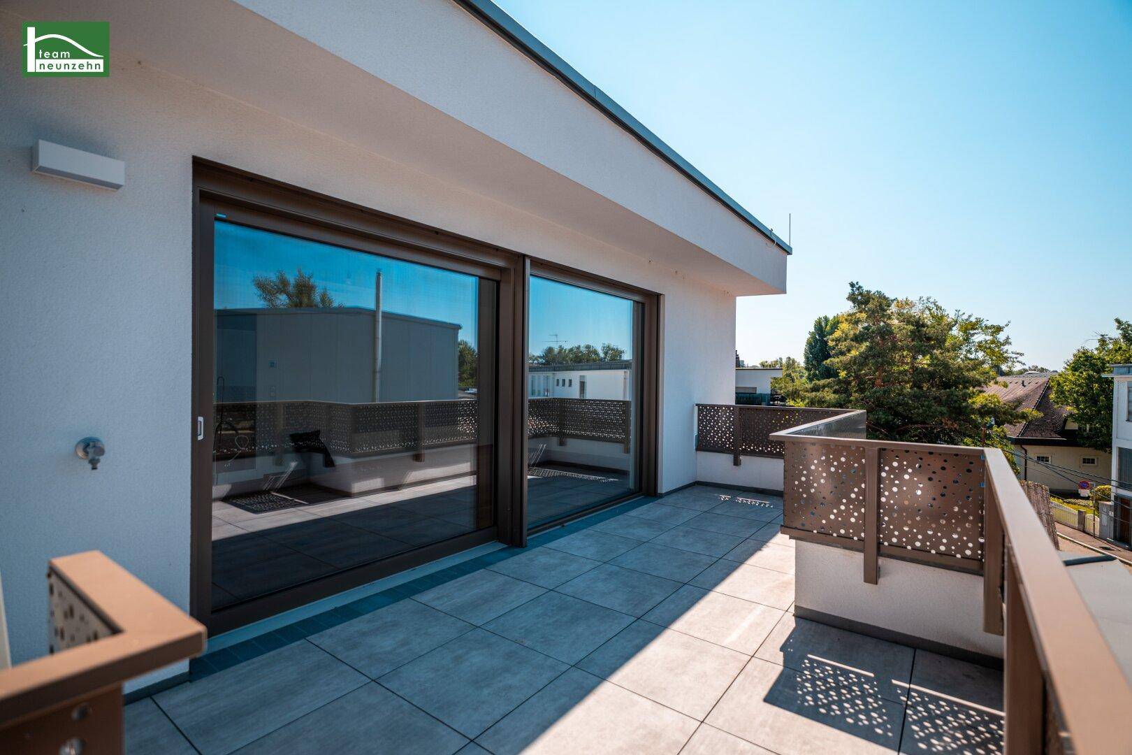 Geräumige Dachterrasse mit Fliesenboden und moderner Lochblech-Brüstung.