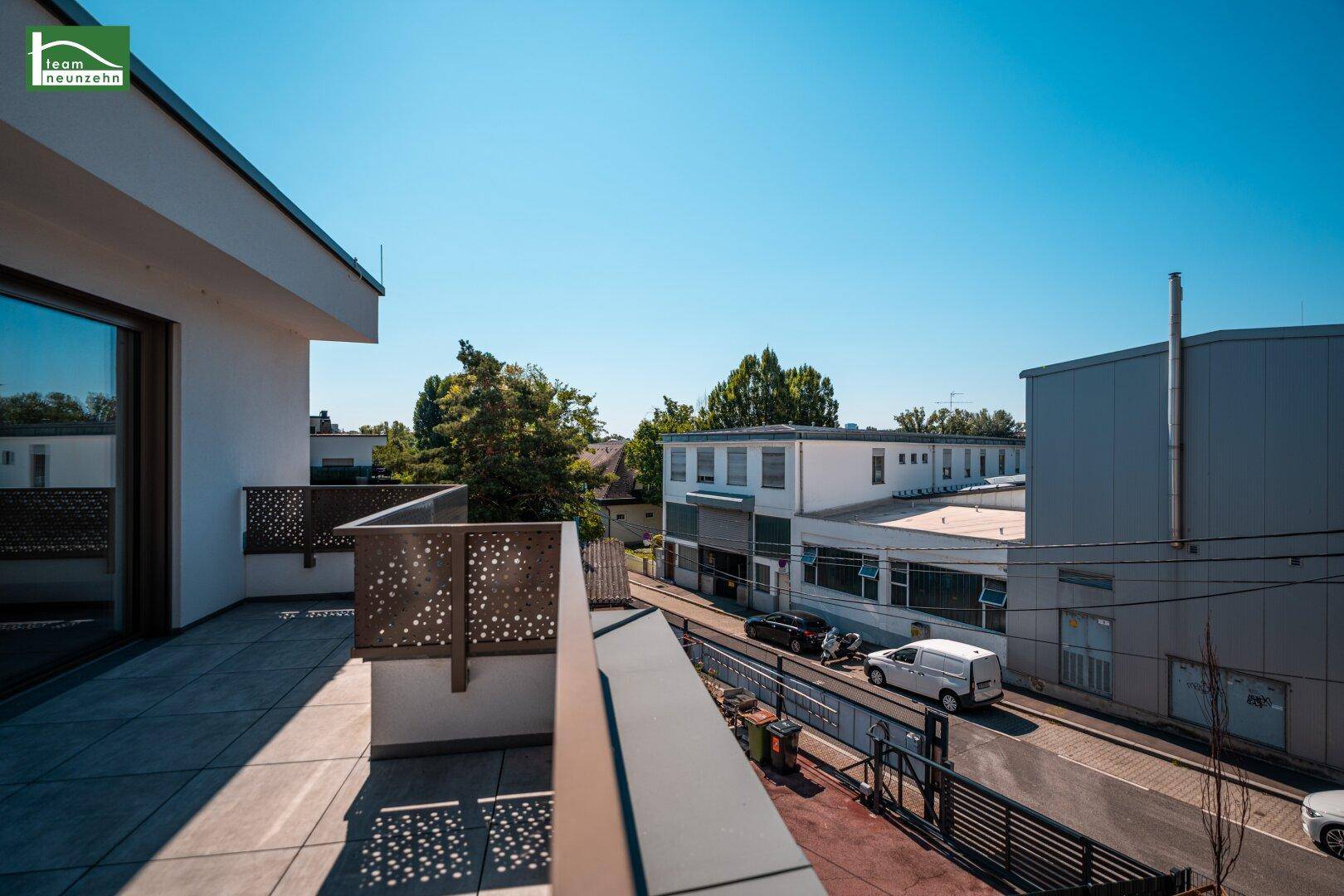 Blick von der Terrasse auf die Straße und die umliegenden Gebäude.