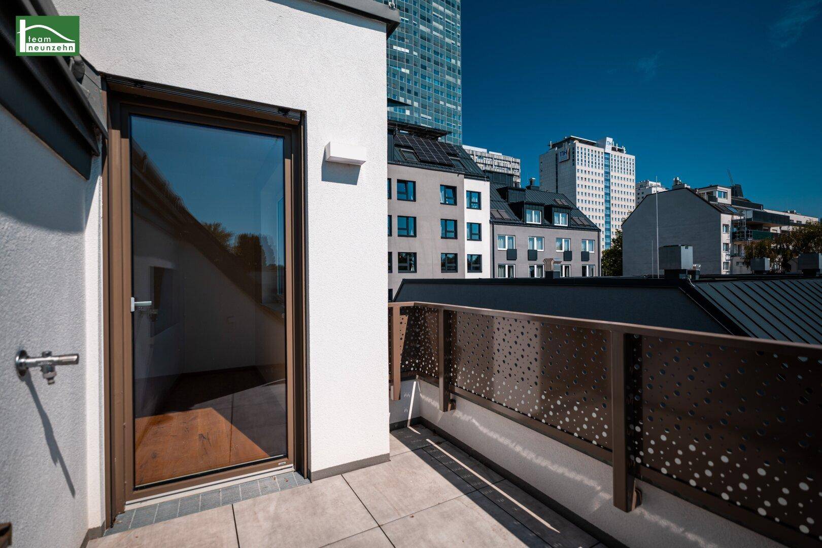 Kleinerer Terrassenbereich mit Zugang zum Innenraum und Blick auf die Stadt.