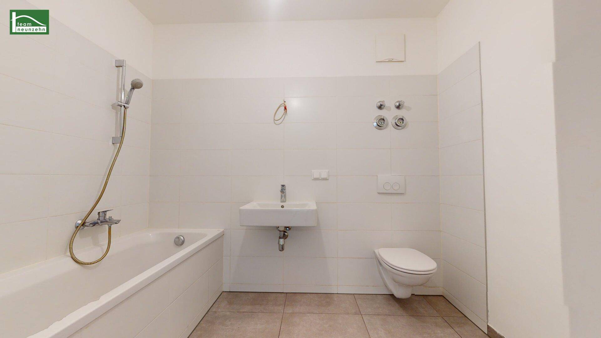 Modernes Badezimmer mit Badewanne, Duschfunktion, Waschbecken und wandhängendem WC.