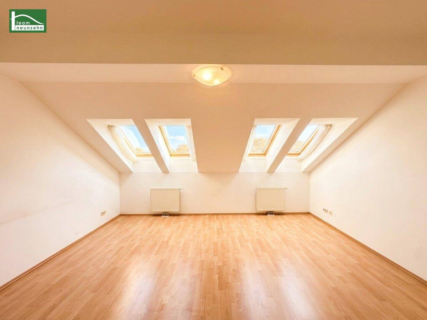 Geräumiges Dachgeschosszimmer mit Holzboden und vier Dachfenstern für viel Tageslicht.