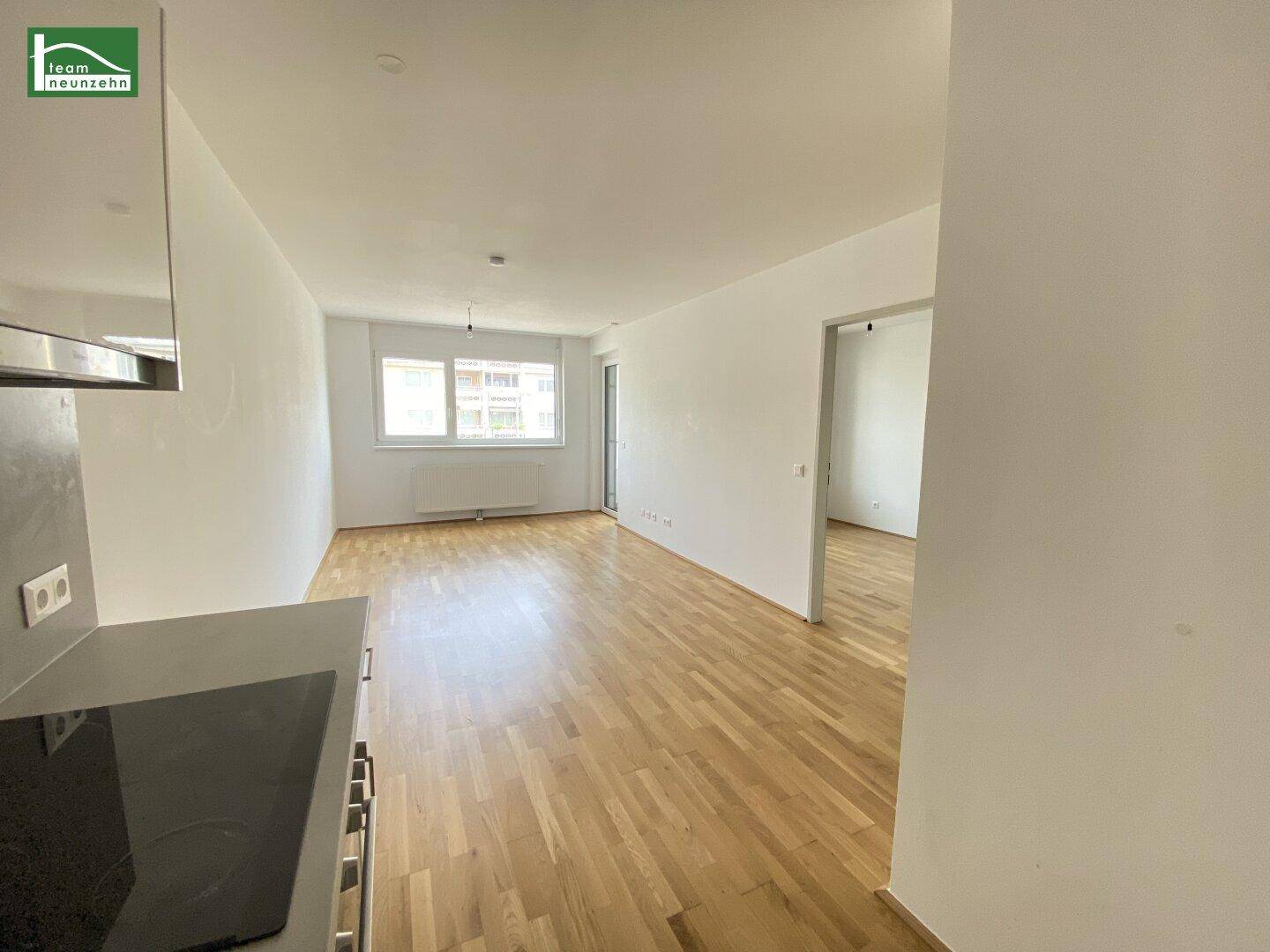 Geräumiger Wohn- und Essbereich mit Holzboden und viel Tageslicht.
