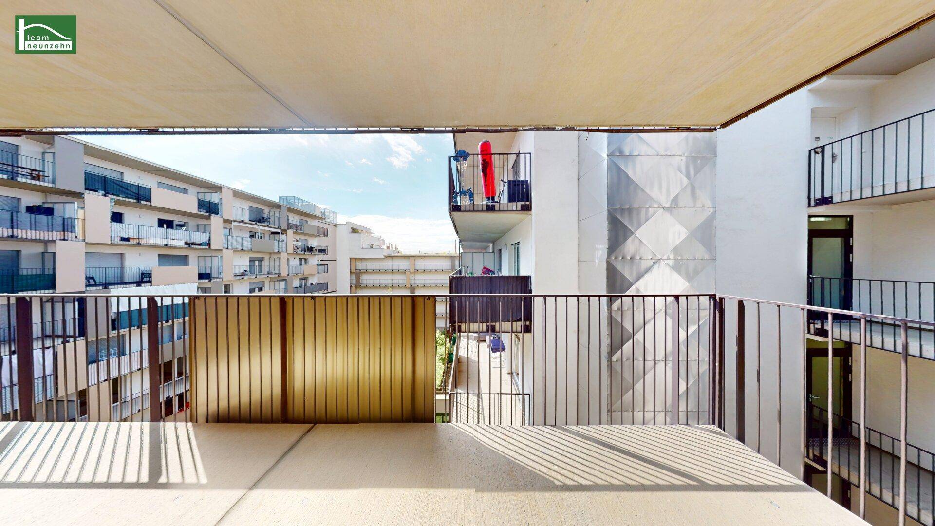 Geräumiger Balkon mit Blick auf die umliegenden Wohngebäude und viel Tageslicht.