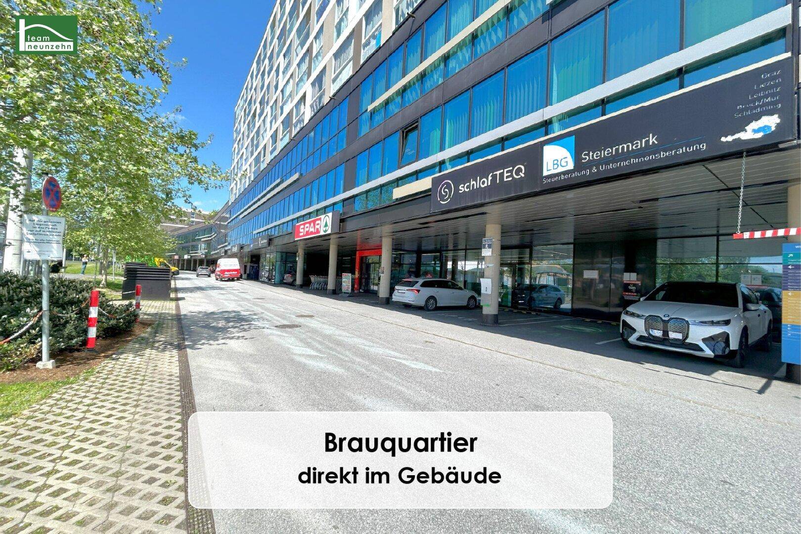 Moderne Geschäftsfassade mit Geschäften und Parkplätzen im Brauquartier, direkt im Gebäude.
