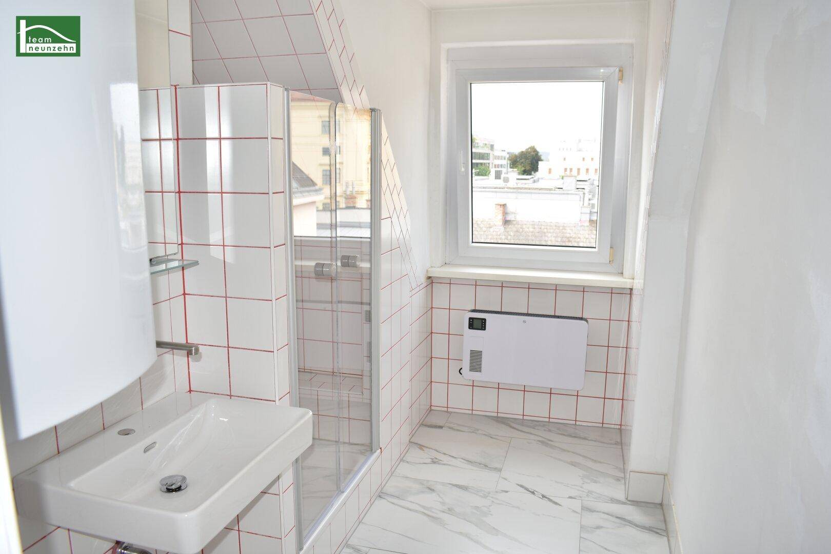 Modernes Badezimmer mit Dusche, Waschbecken und auffälligen rot-weißen Fliesen im Dachgeschoss.