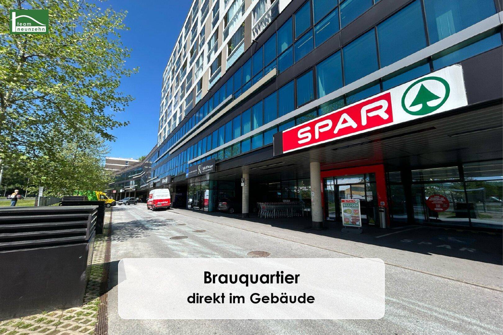 Straßenansicht des Gebäudes mit einem Supermarkt im Erdgeschoss, direkt im Brauquartier gelegen.