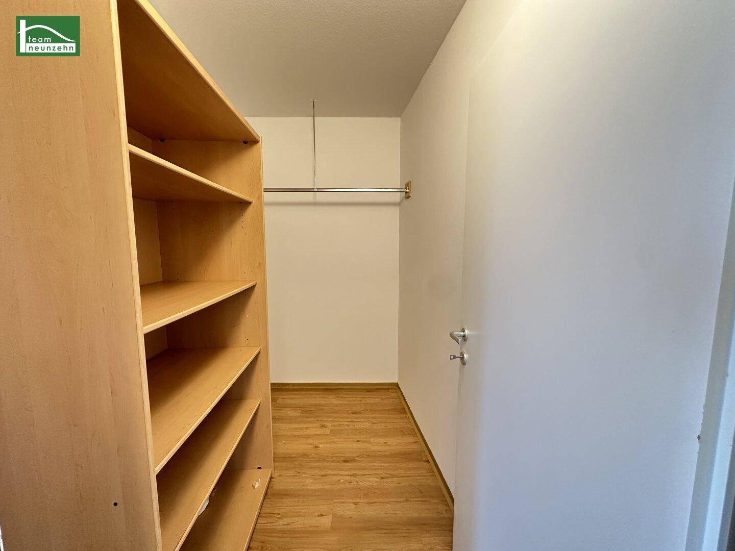 Praktischer Abstellraum mit Regalen und Kleiderstange, ideal als begehbarer Kleiderschrank.