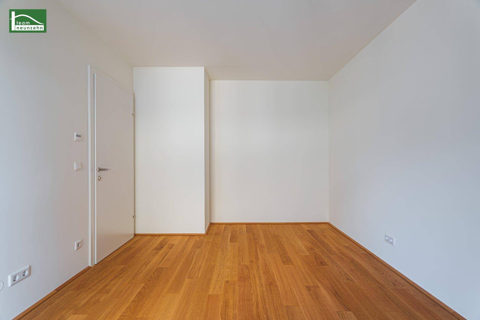 Helles Zimmer mit Parkettboden und weiß gestrichenen Wänden, bereit zur individuellen Gestaltung.