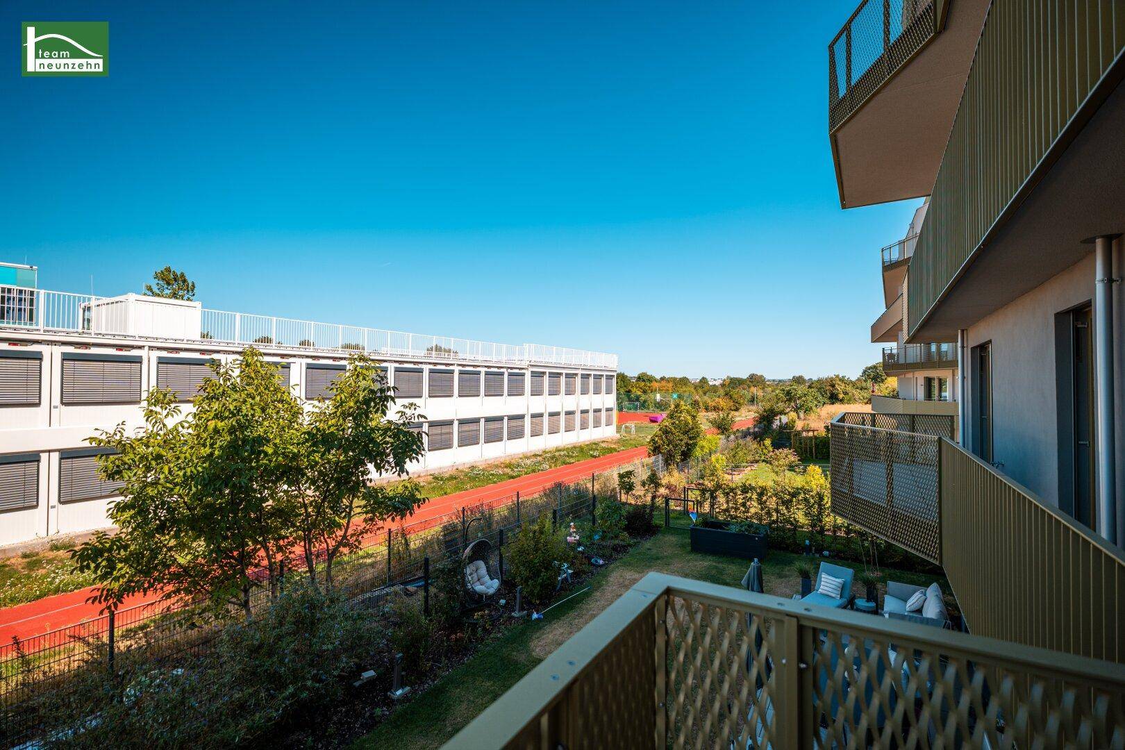 Balkon mit Blick auf den Gartenbereich mit Sitzgelegenheiten und die umliegende Natur.