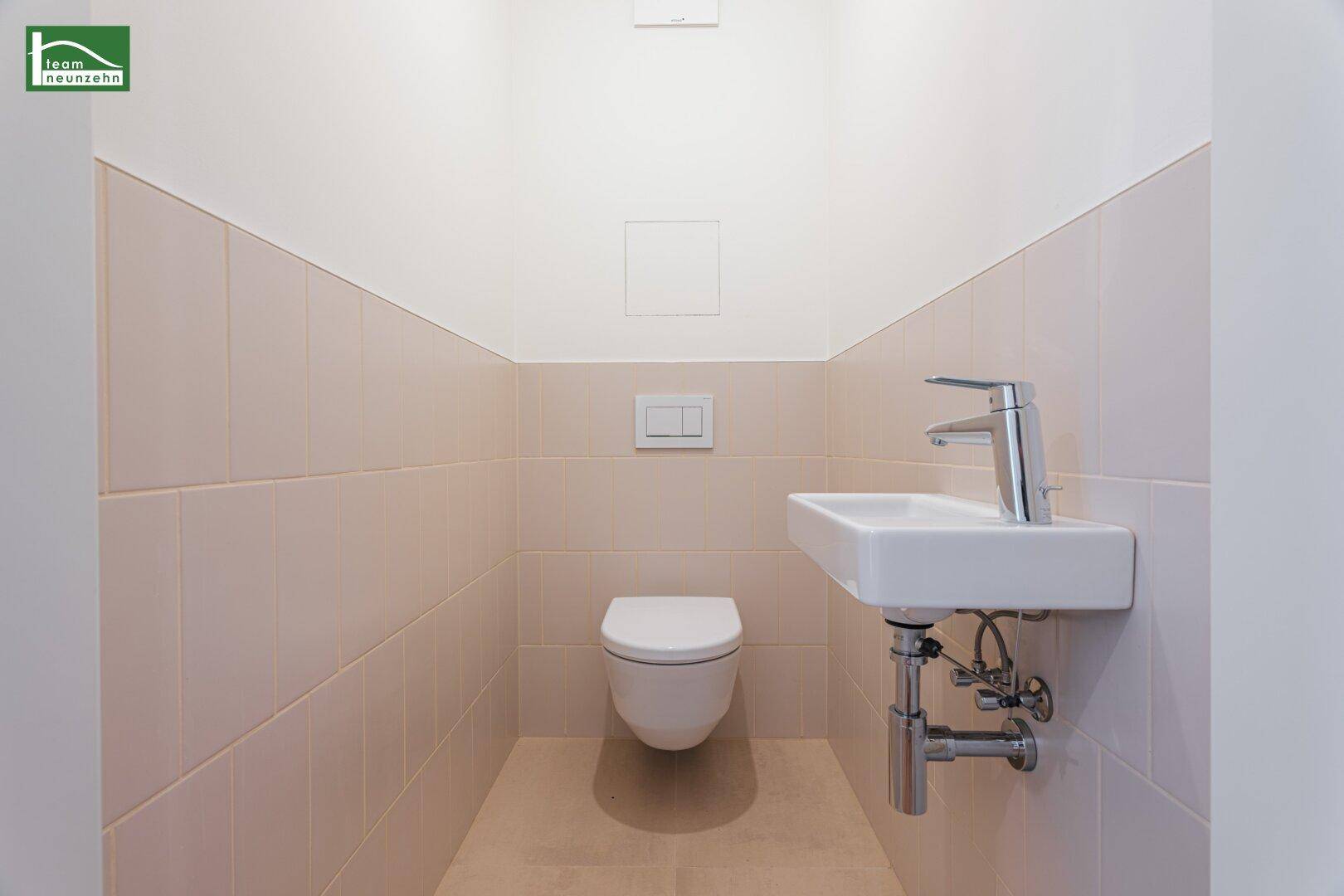 Kleines Gäste-WC mit wandhängender Toilette und einem kompakten Waschbecken.