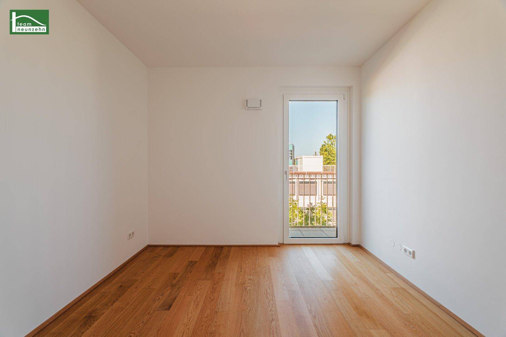Heller Raum mit Holzboden und Zugang zu einem französischen Balkon, bietet Tageslicht.