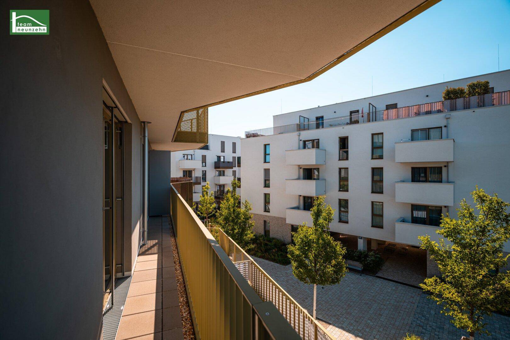 Balkon mit Blick auf den Innenhof und die moderne Architektur der Wohnanlage.
