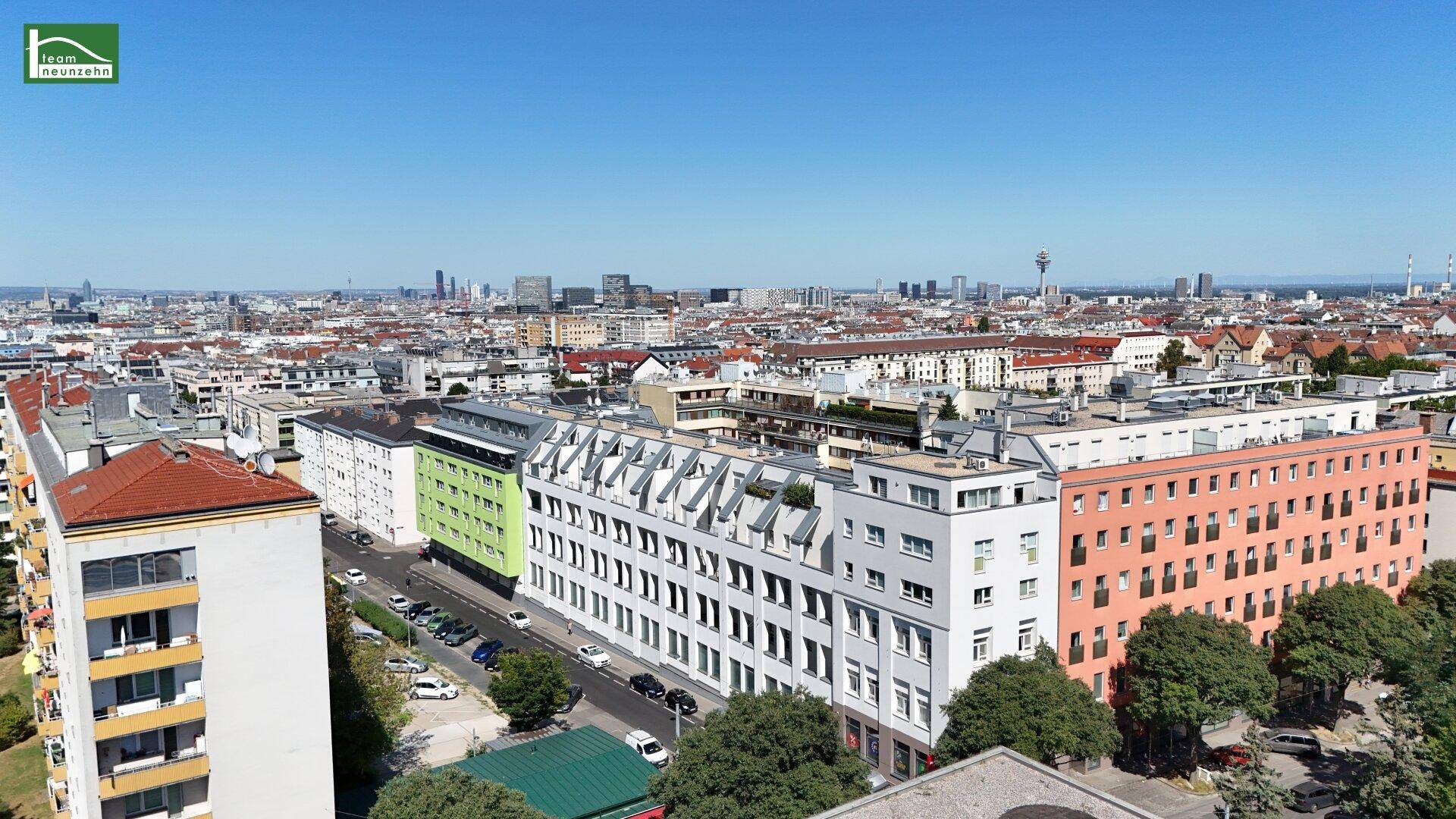 Panoramablick über eine städtische Bebauung mit verschiedenen Gebäudefarben und einer weiten Stadtsilhouette.