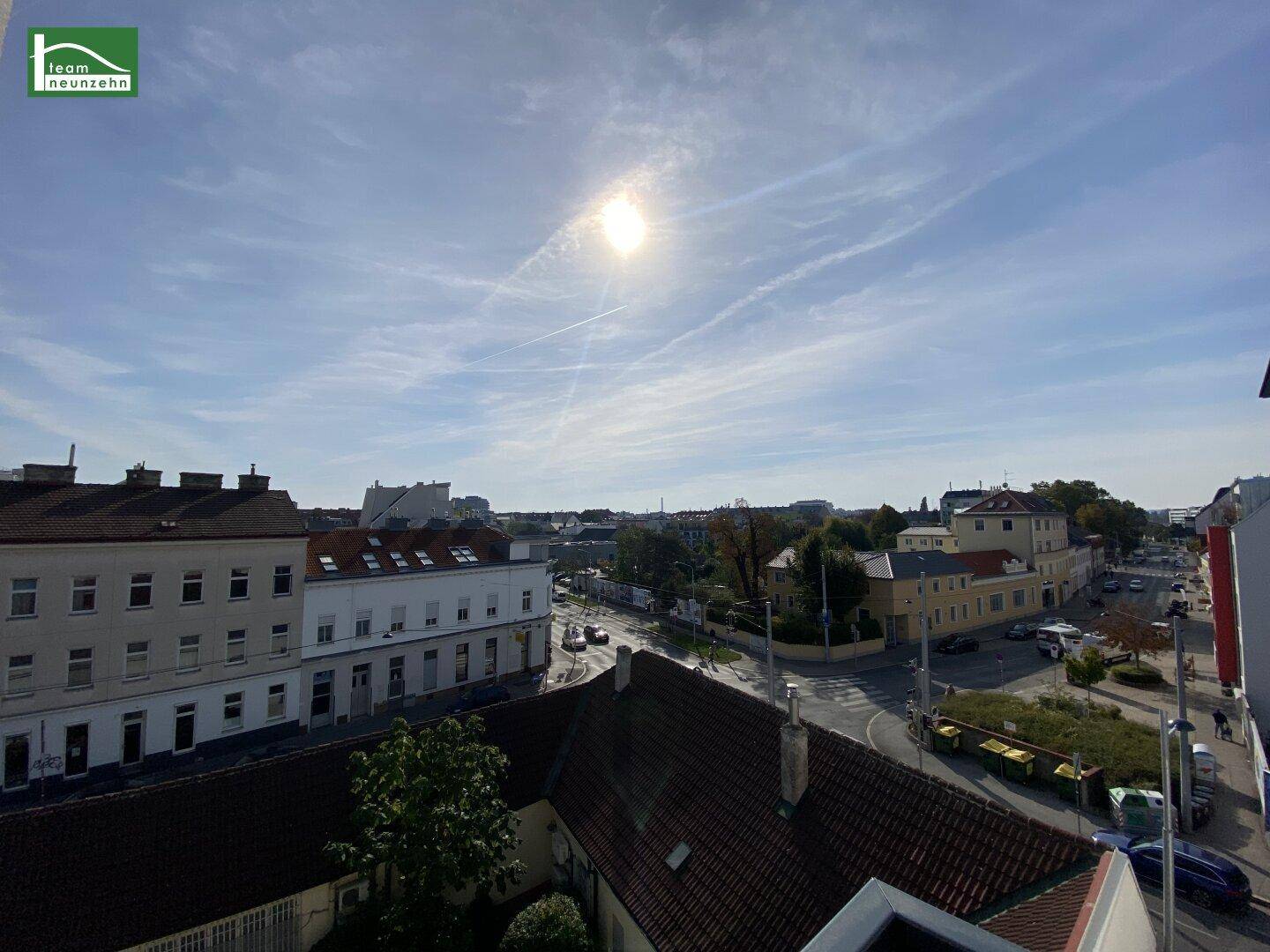 Panoramablick über die Stadt mit vielen Dächern und Gebäuden unter blauem Himmel.