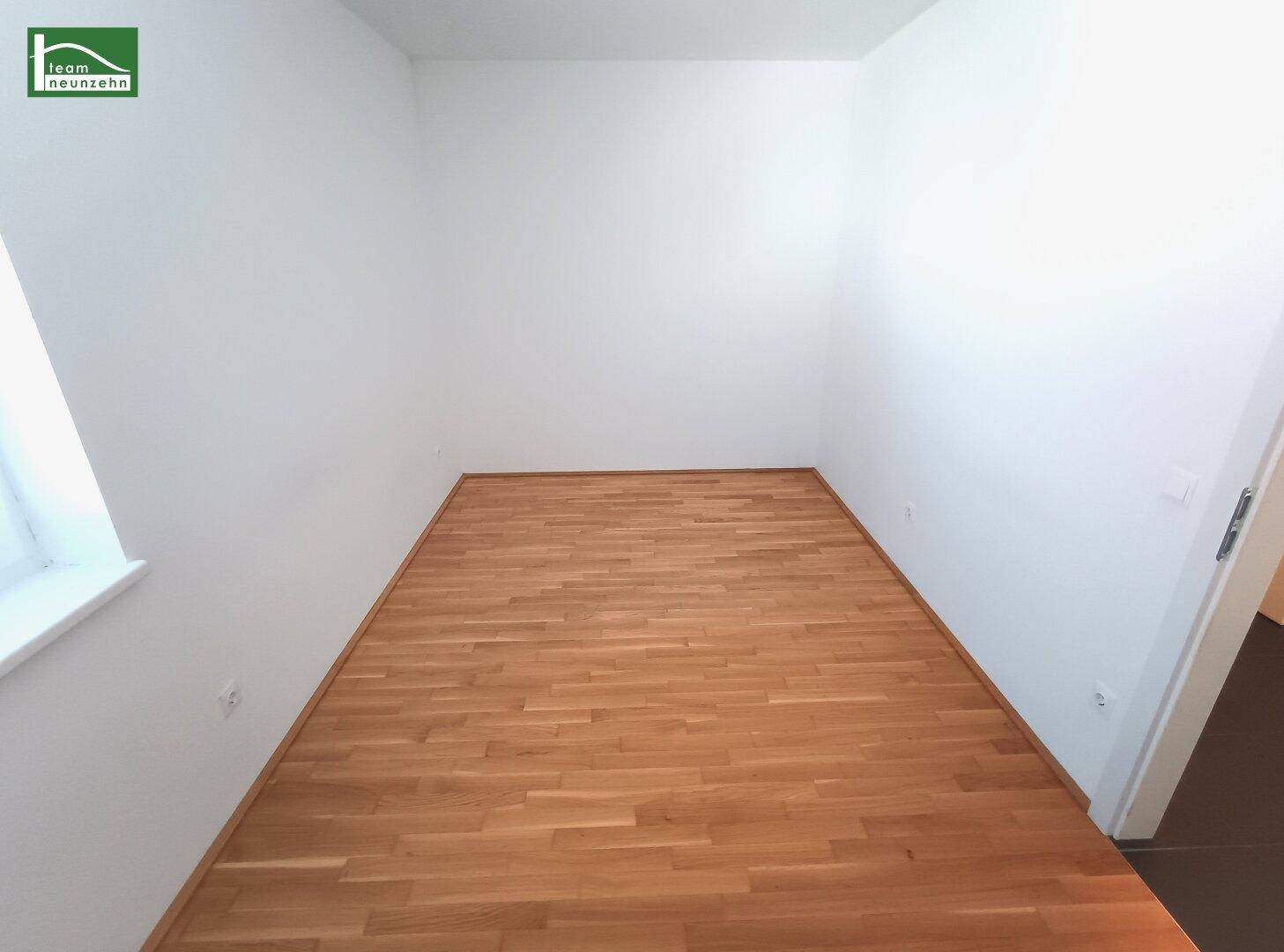 Unmöbliertes Schlafzimmer mit hellem Parkettboden und weißen Wänden, ideal für persönliche Einrichtung.