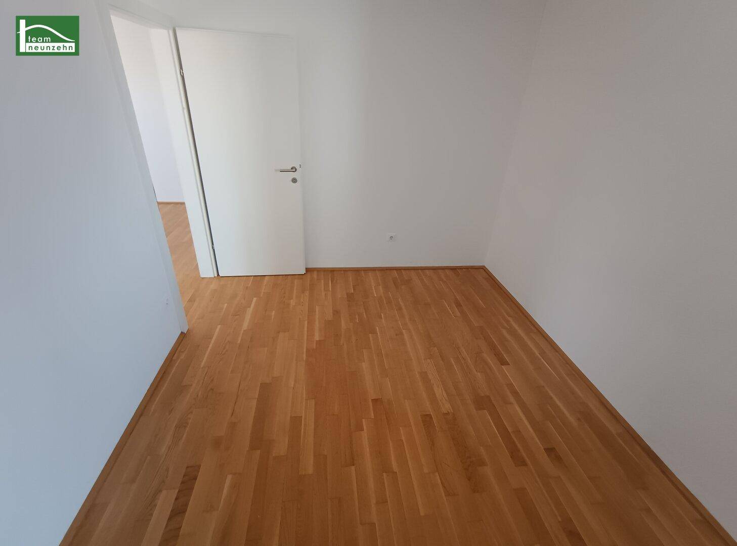 Leeres Schlafzimmer mit Parkettboden und weiß gestrichenen Wänden, bereit zur Möblierung.