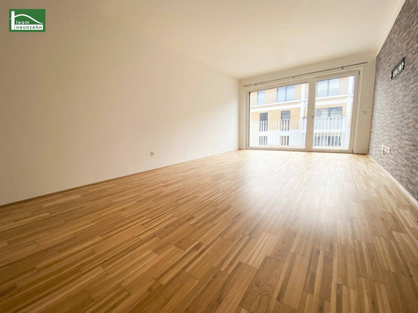 Geräumiges Wohnzimmer mit Parkettboden, heller Wandfarbe und dekorativer Steinwand.