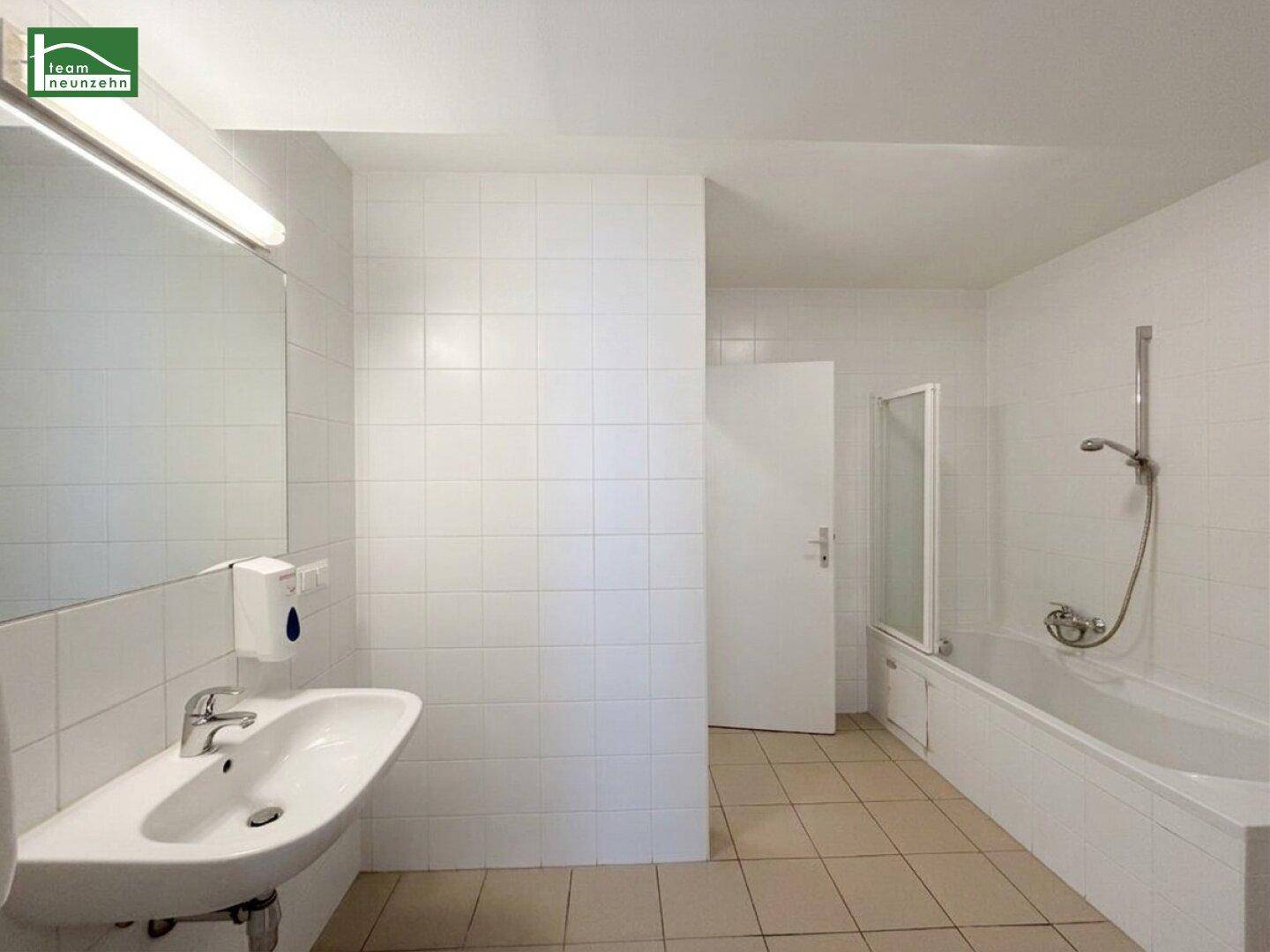 Gefliestes Badezimmer mit Badewanne, Dusche und Waschbecken, in gutem Zustand.