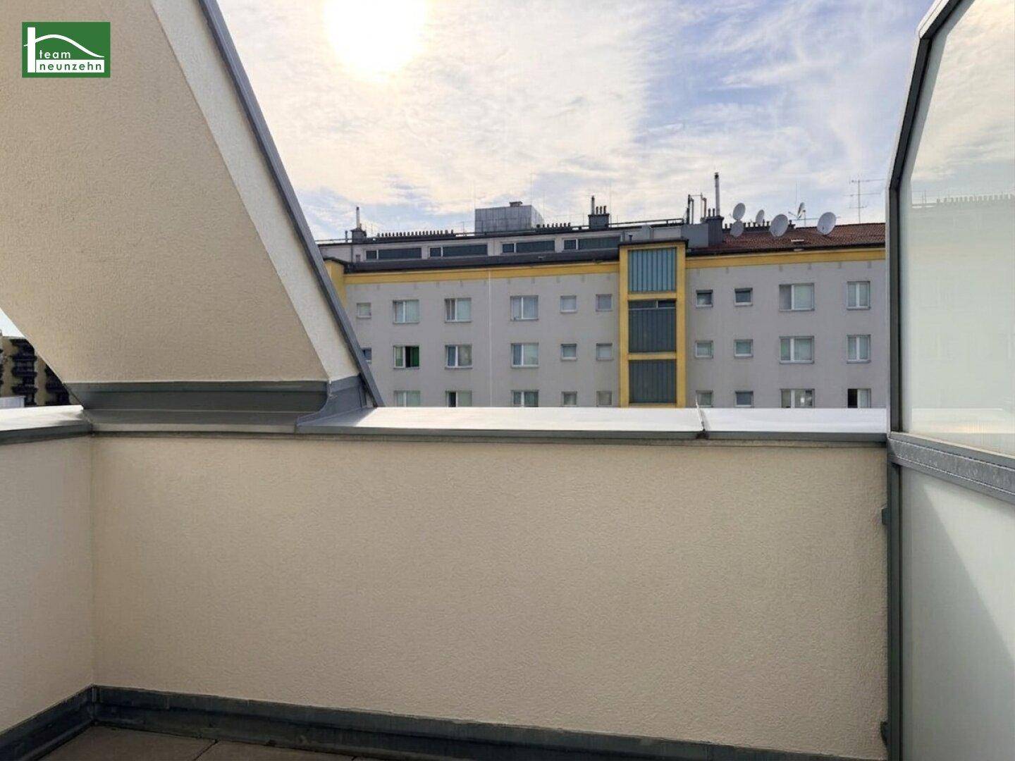 Kleiner Außenbereich mit Blick auf die umliegenden Gebäude und den Himmel.