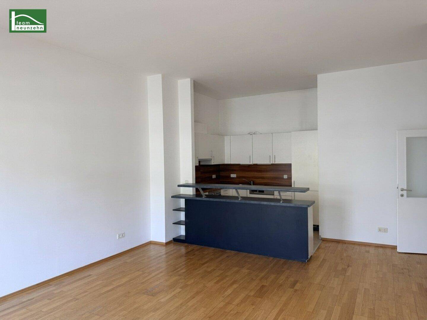 Offener Wohnbereich mit integrierter Küche und einer modernen Frühstücksbar für geselliges Beisammensein.