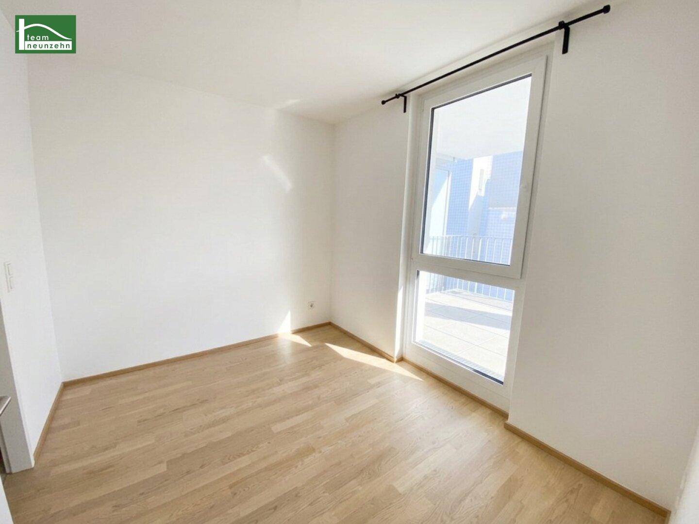 Helles Schlafzimmer mit Holzboden und direktem Zugang zu einem Außenbereich.