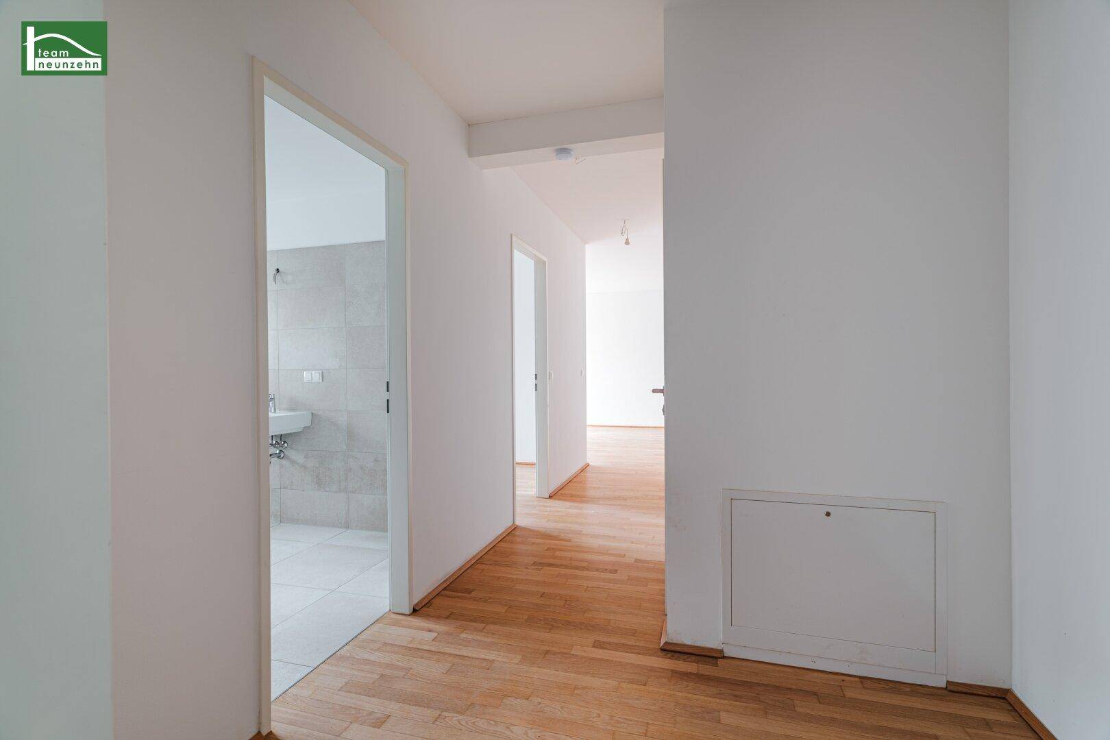 Heller Flur mit Parkettboden, der zu verschiedenen Räumen der Wohnung führt.
