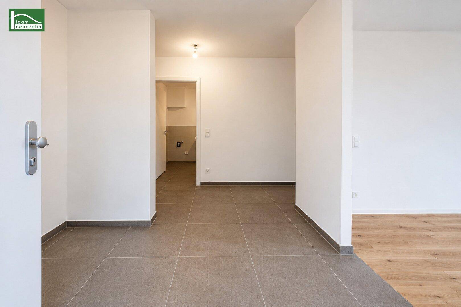 Eingangsbereich mit Fliesenboden, der zu weiteren Räumen der Wohnung führt.