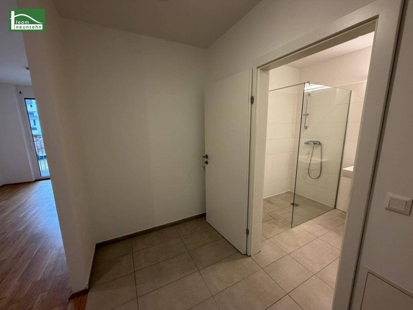 Heller Flurbereich mit Fliesenboden und Zugang zum Badezimmer.