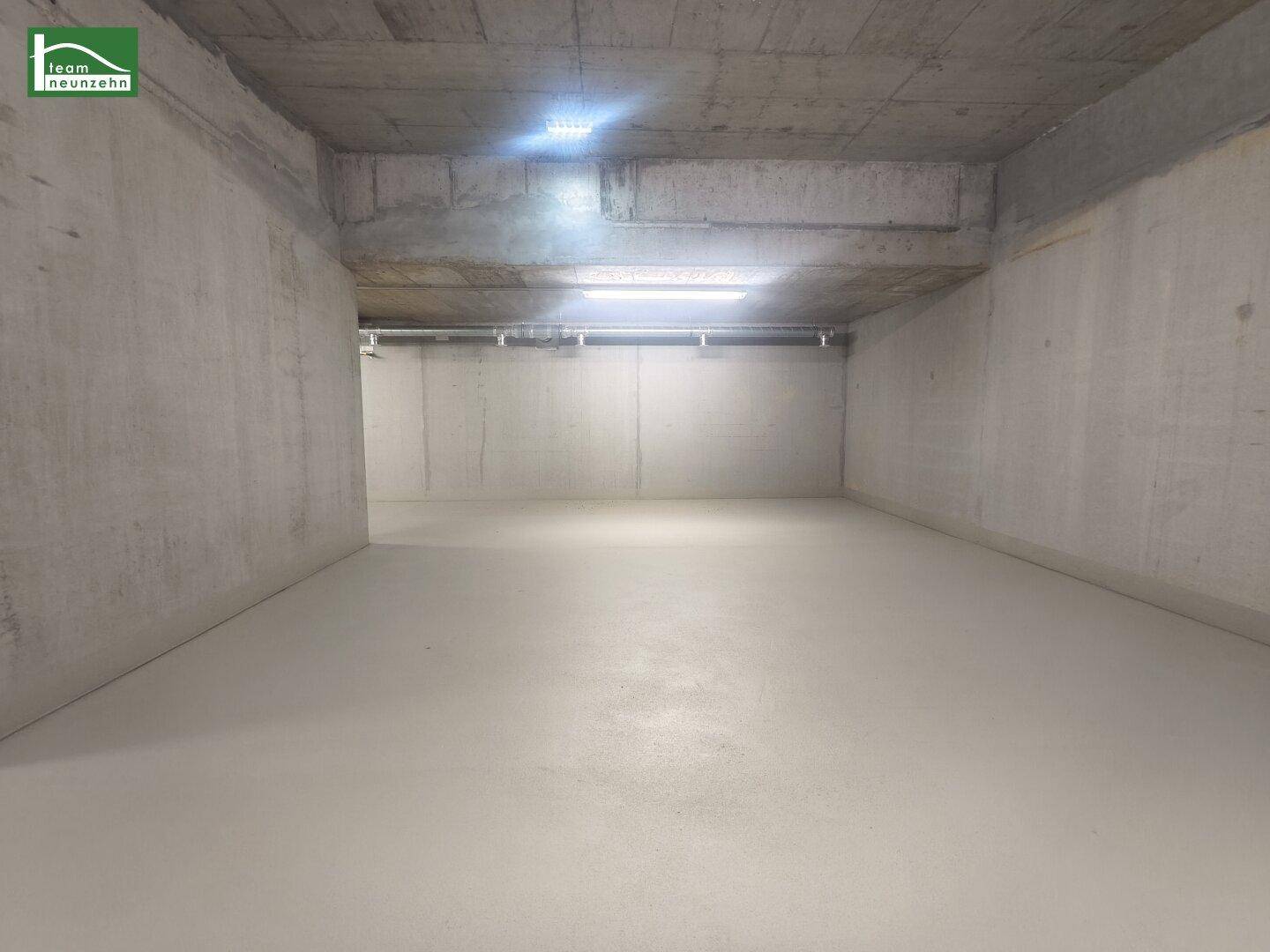 Langer, leerer Betonraum im Untergeschoss mit Deckenbeleuchtung und sauberen Oberflächen.