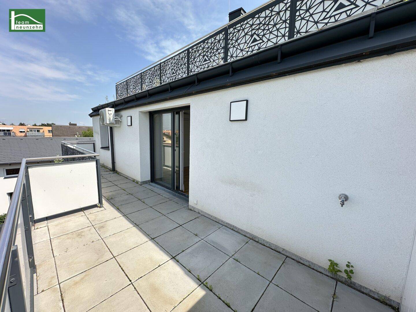 Außenansicht der Terrasse mit modernem Geländer und Blick auf die Umgebung.