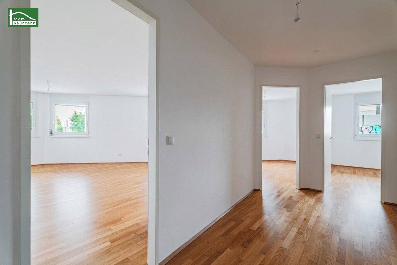 Heller Flur mit Parkettboden und Zugängen zu mehreren Zimmern, die viel natürliches Licht erhalten.